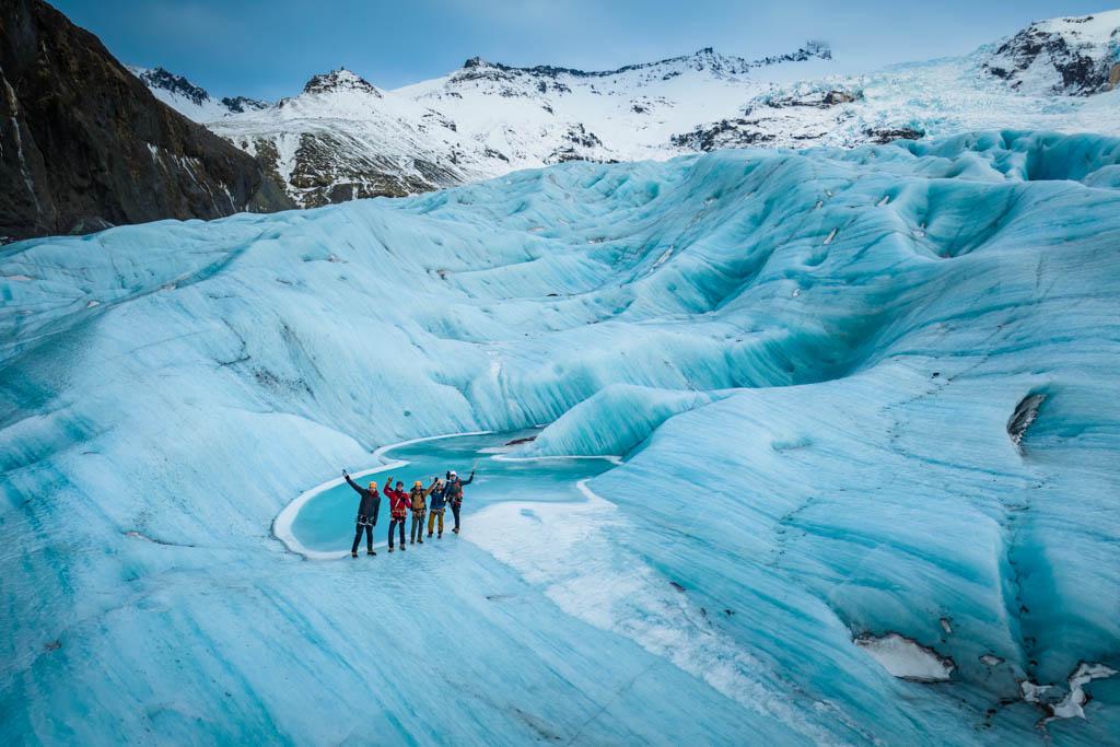 An aerial photo of a group of glacier hikers standing on the blue Virkilsjökull glacier