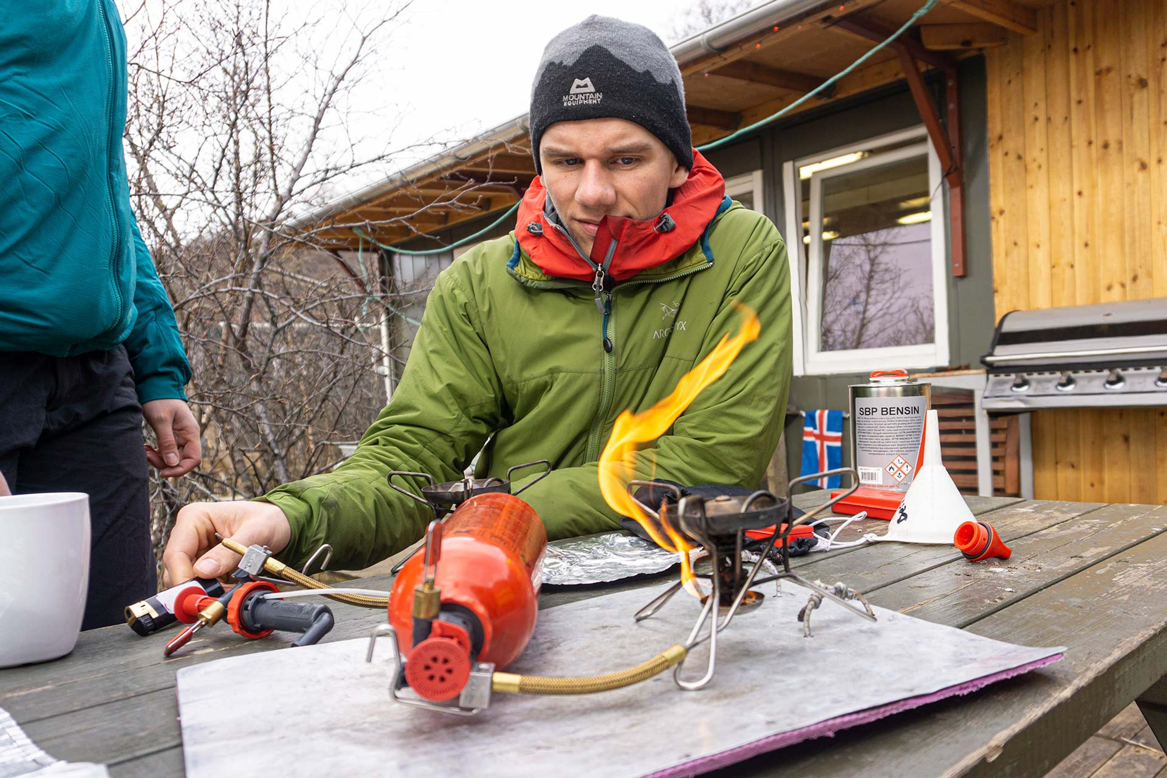 A student learning how to operate an expedition fuel burner