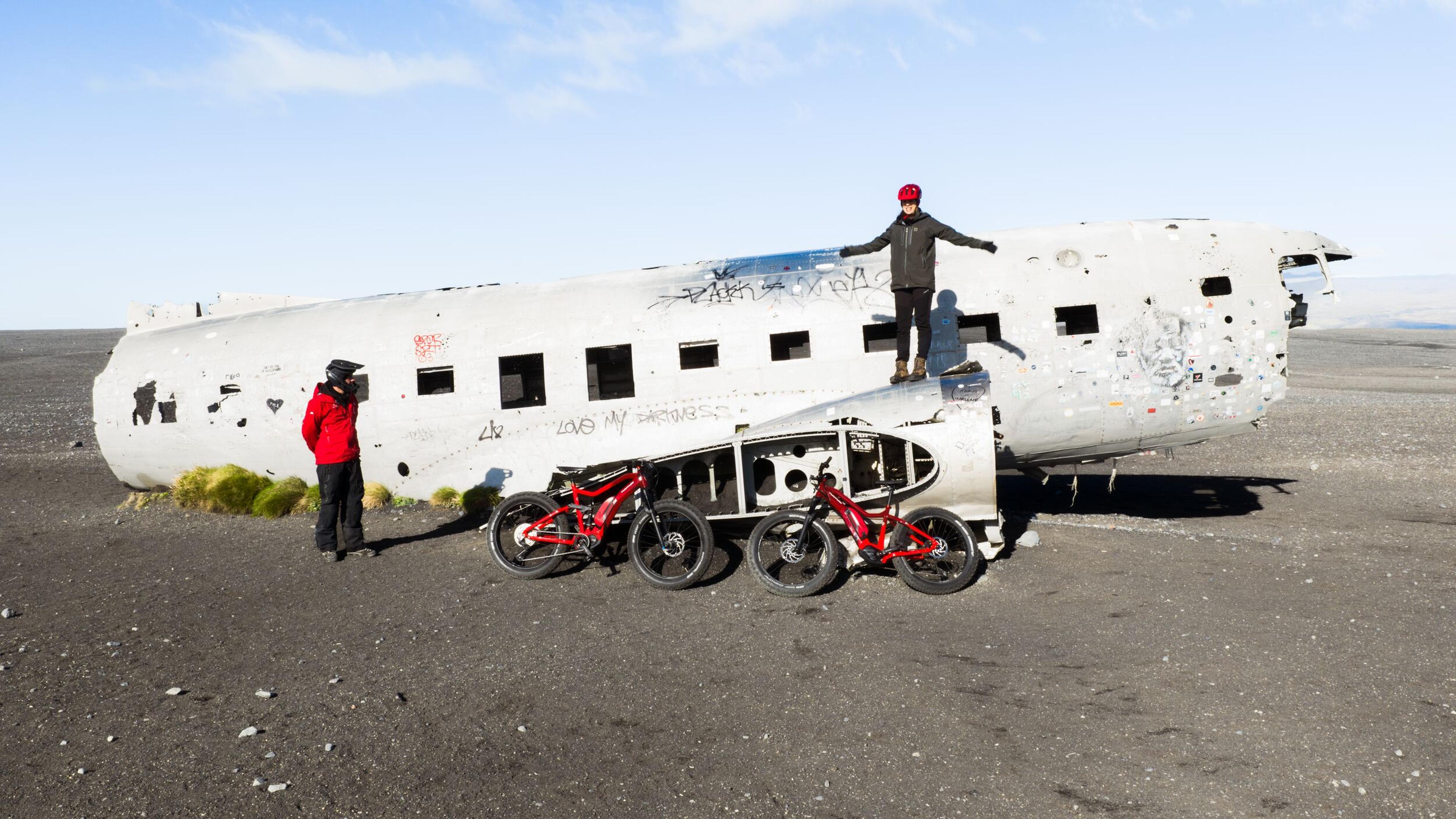 People by a plane wreck with two bikes
