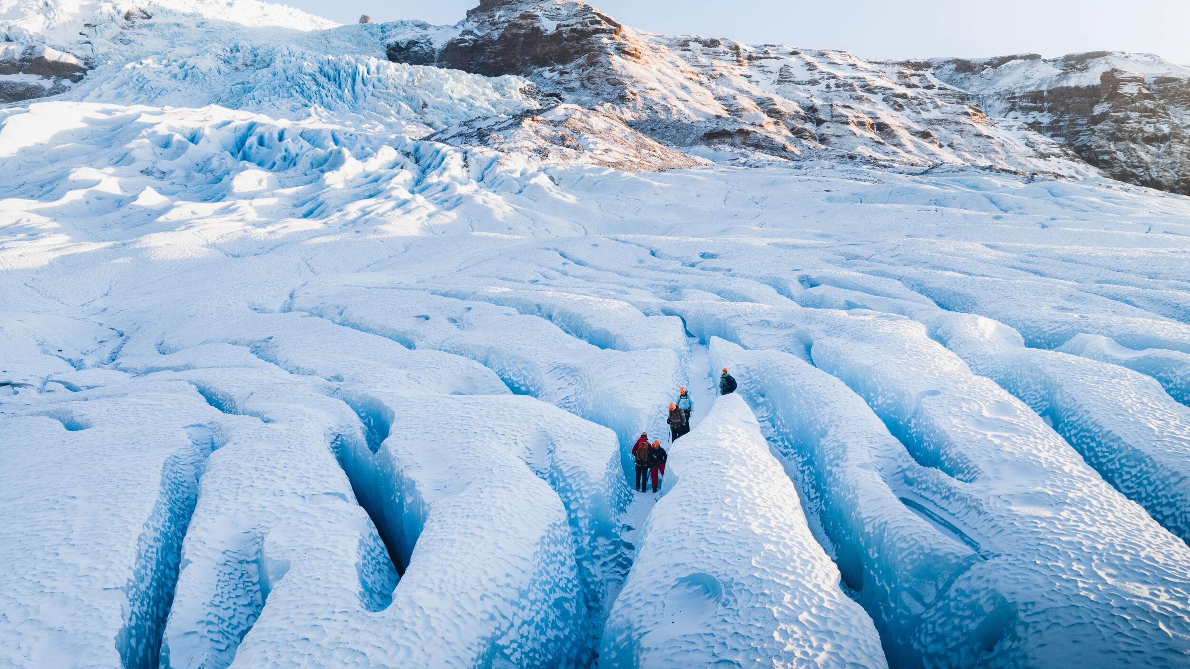 A top view of a group of explorers stood in a shallow crevasse on a glacier