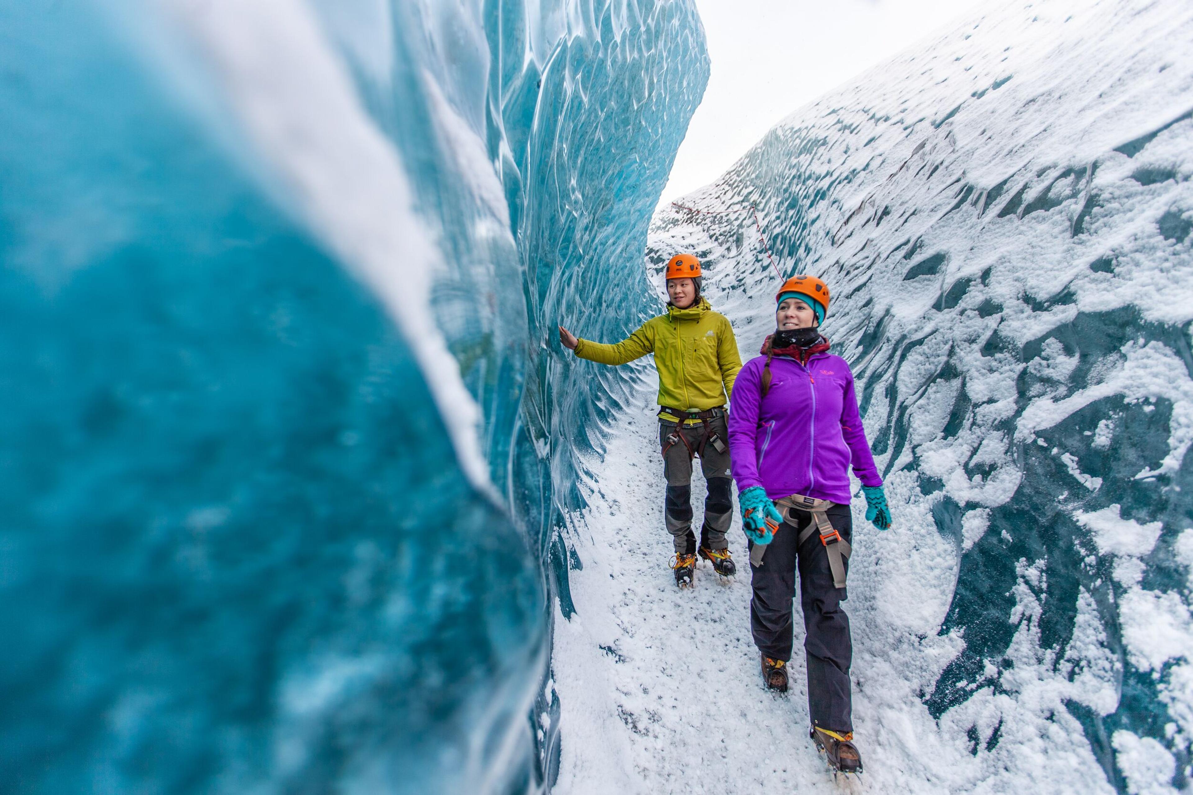 two people walking on blue ice