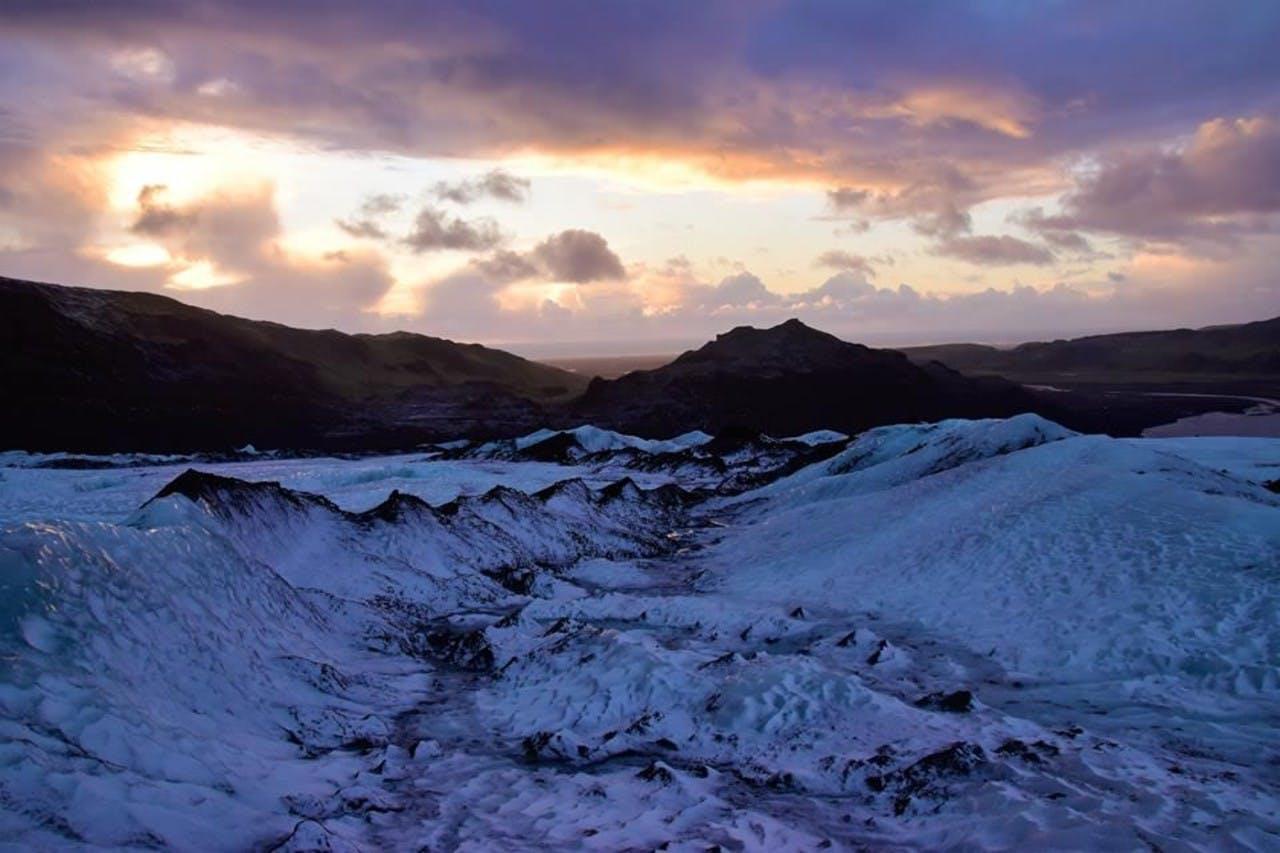 beautiful blue ice under an orange and purple sky