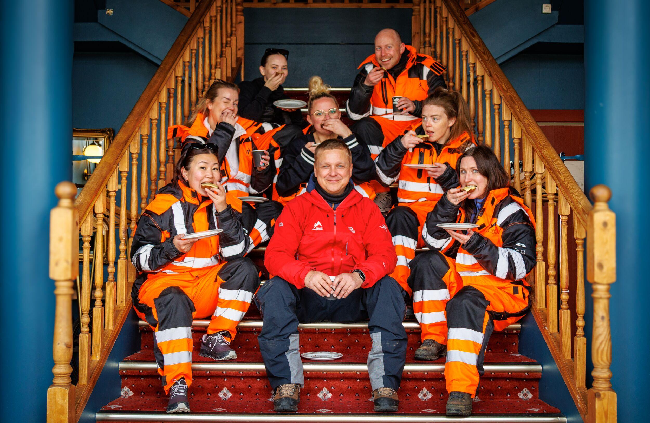 Group seated on stairs, eating traditional rye bread after an ATV tour.