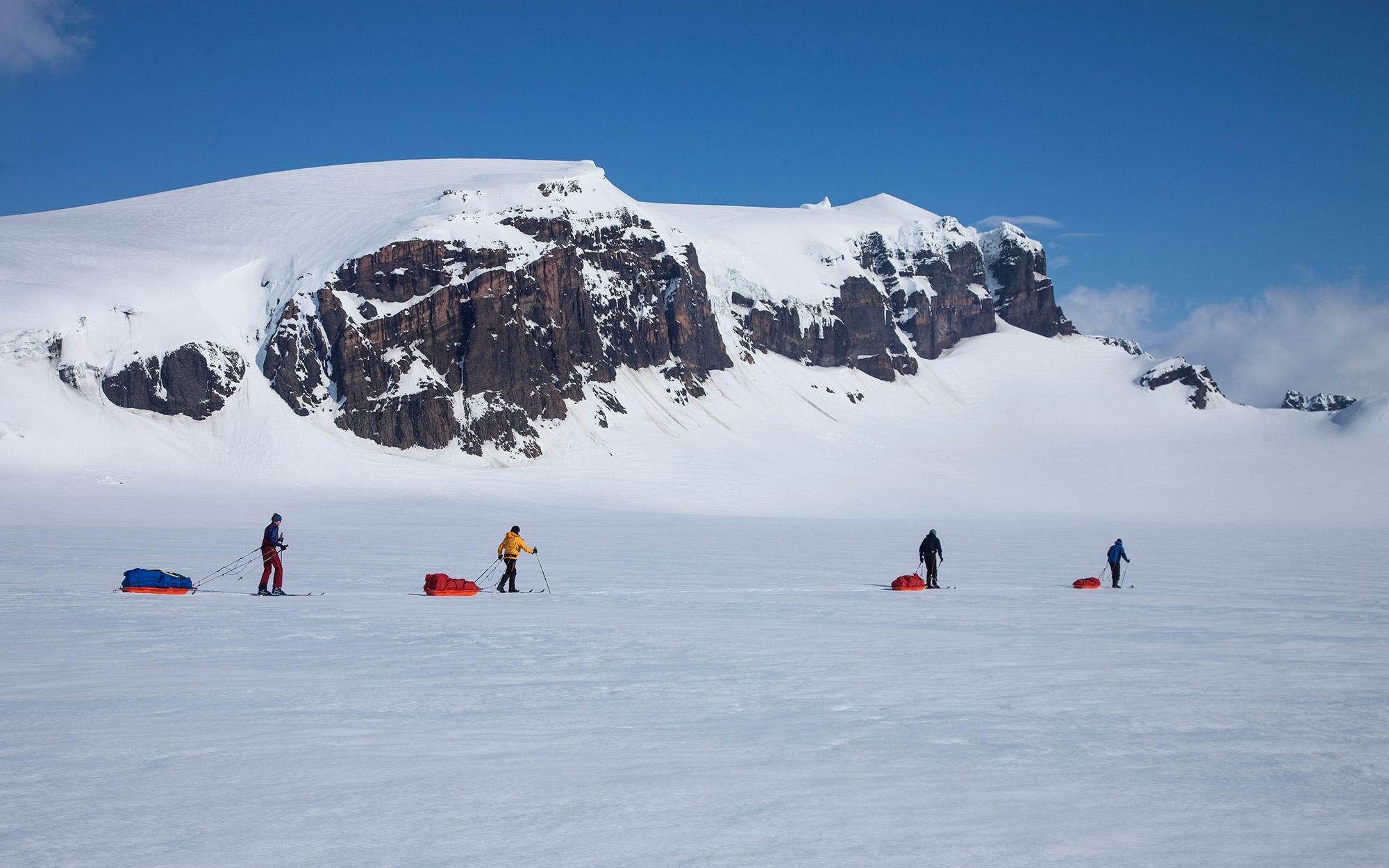 Skiers skiing past Mávabyggðir mountain range getting closer to Esjufjöll mountains
