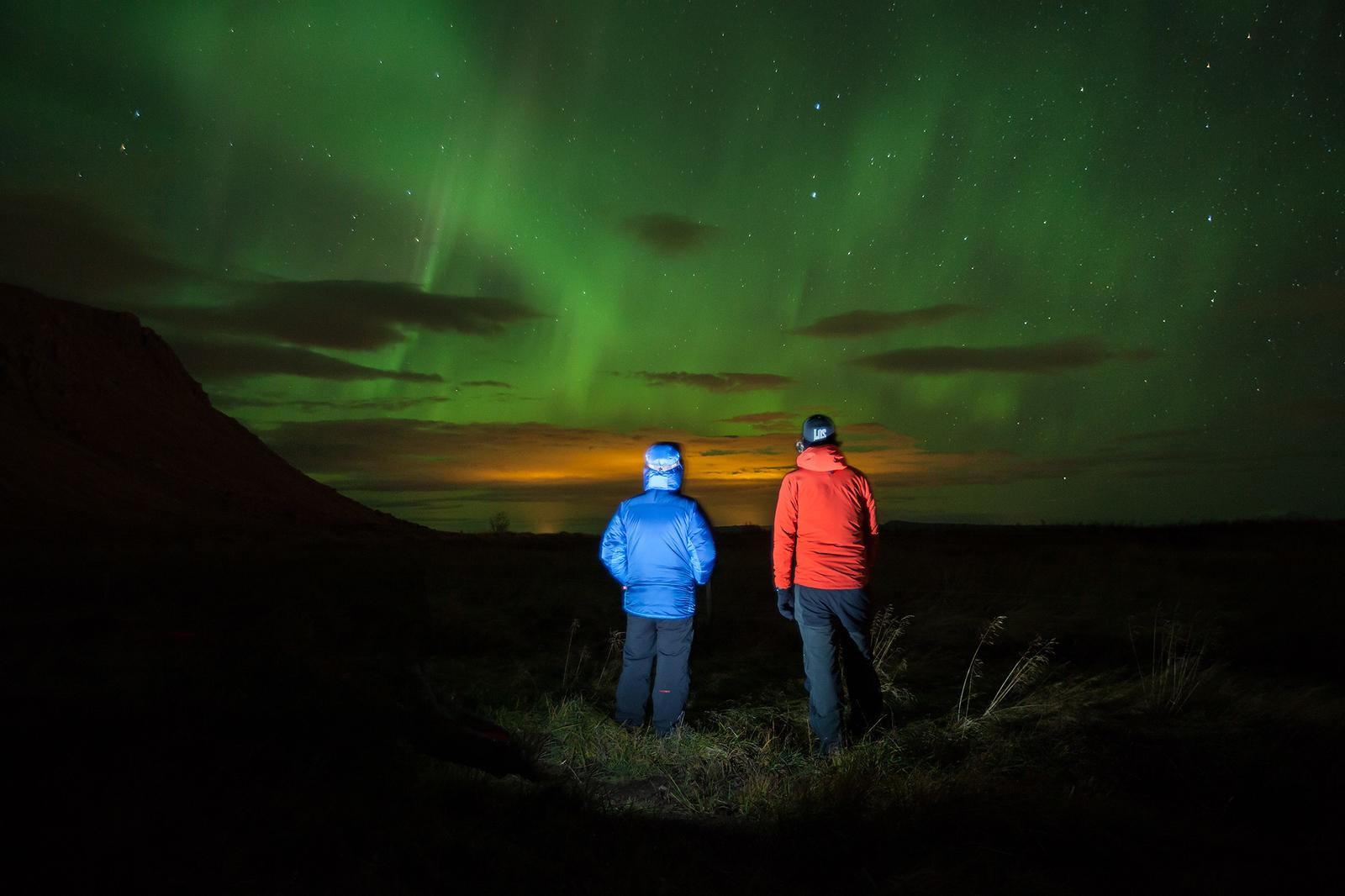 Two guys admiring the northern lights with Icelandic Mountain Guides