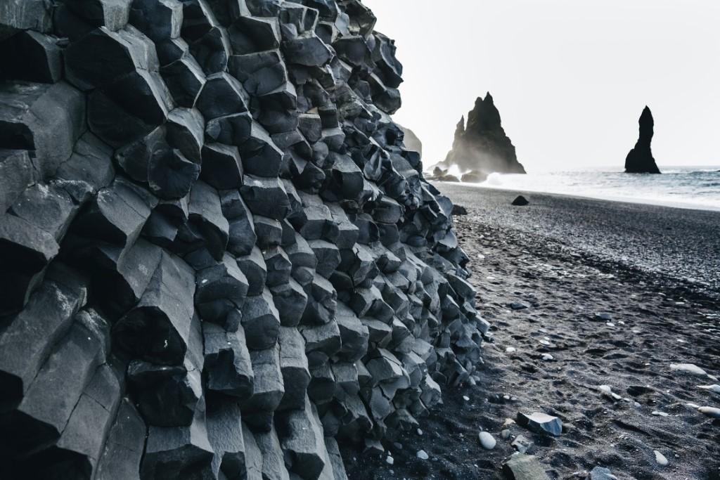 Reynisfjara black sand beach with huge stones in the water at dusk along the south coast of Iceland