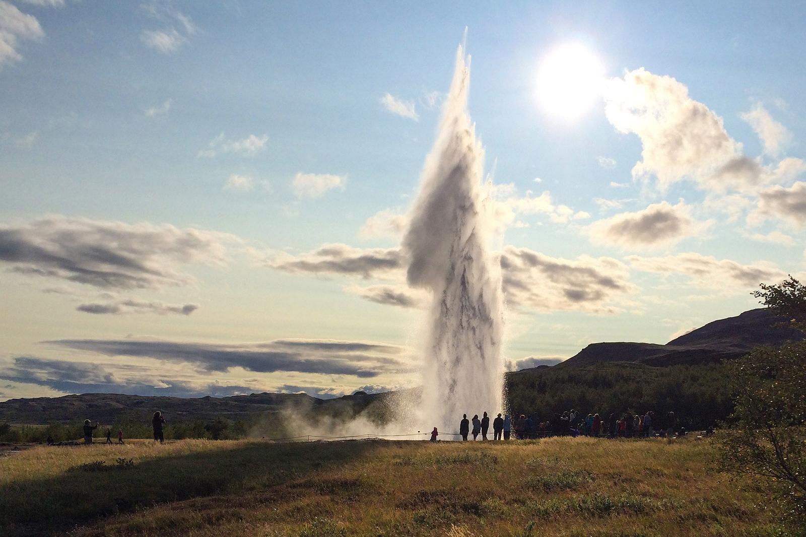 People looking at Geysir erupting.