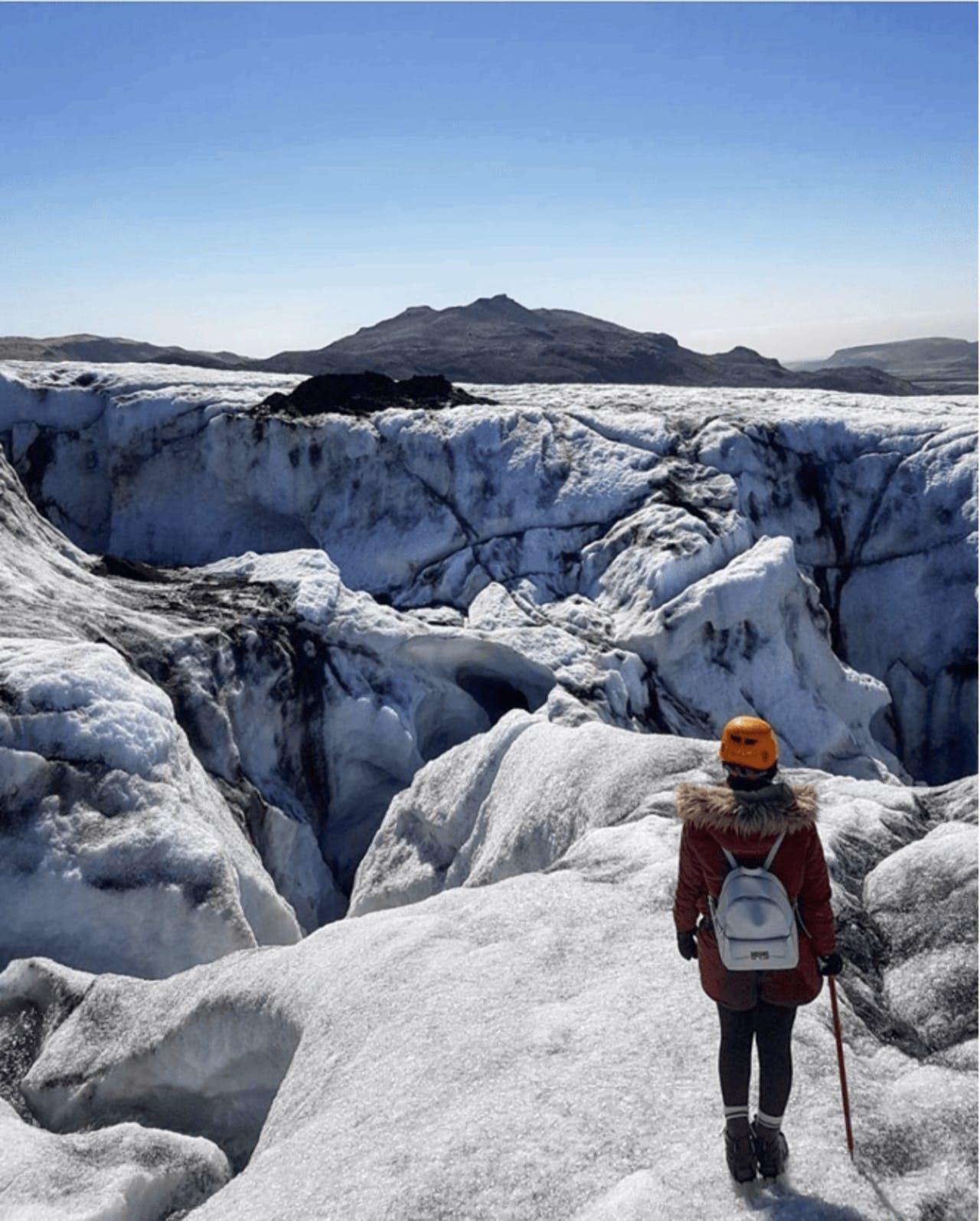 A woman in red standing on Sólheimajökull