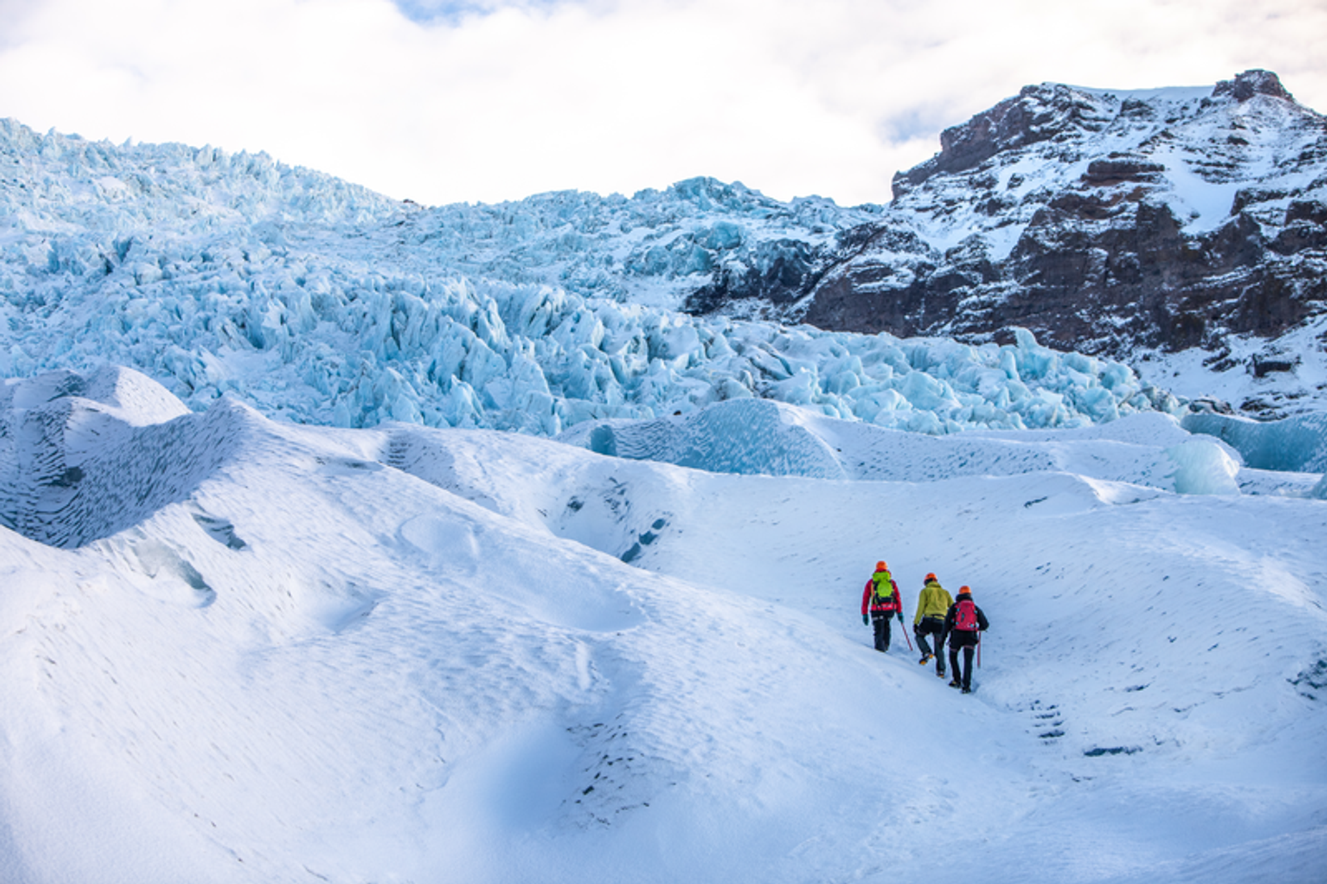 Three hikers going over a glacier tongue in Skaftafell