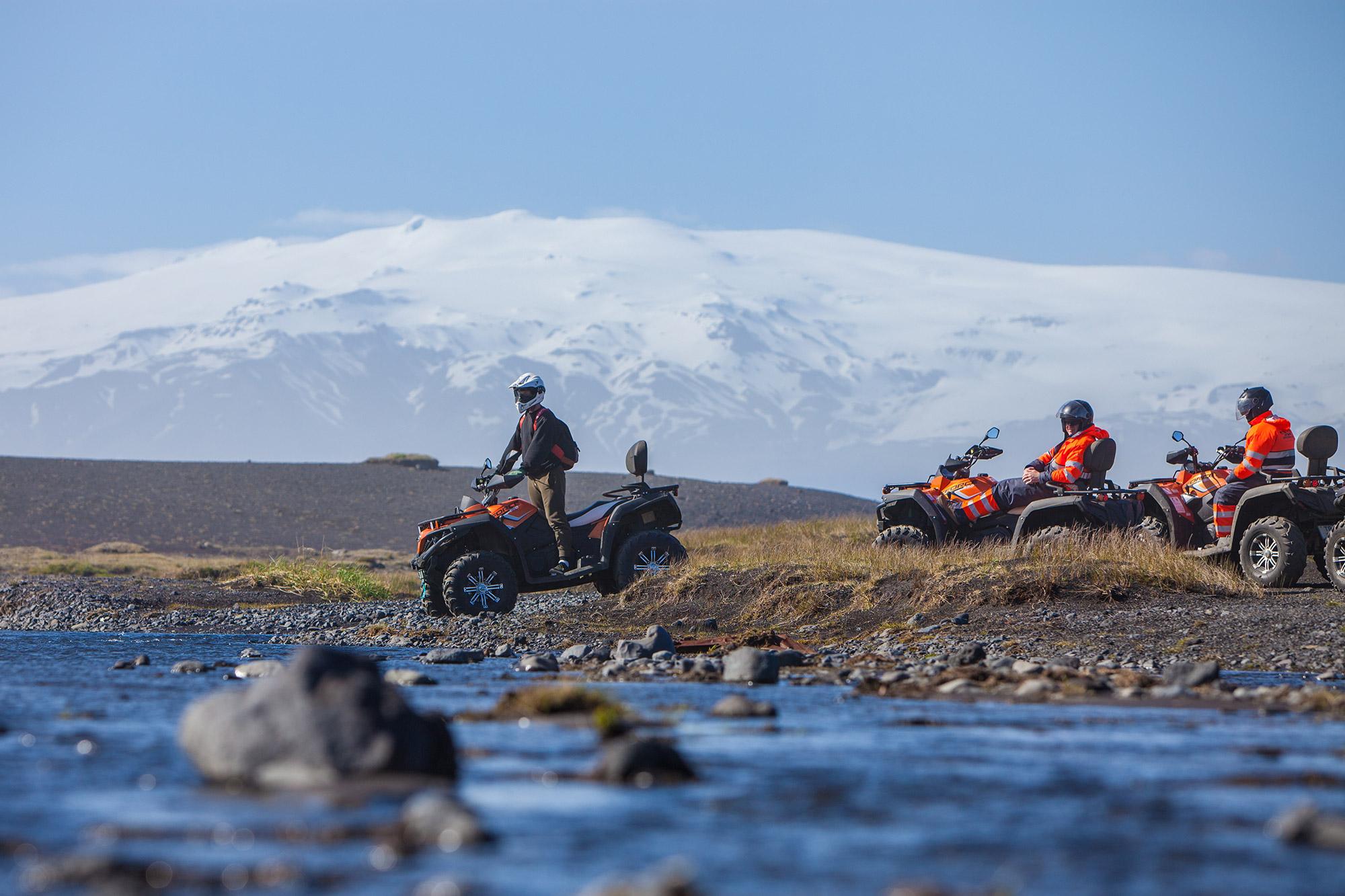 ATV guide leading a group over a small river