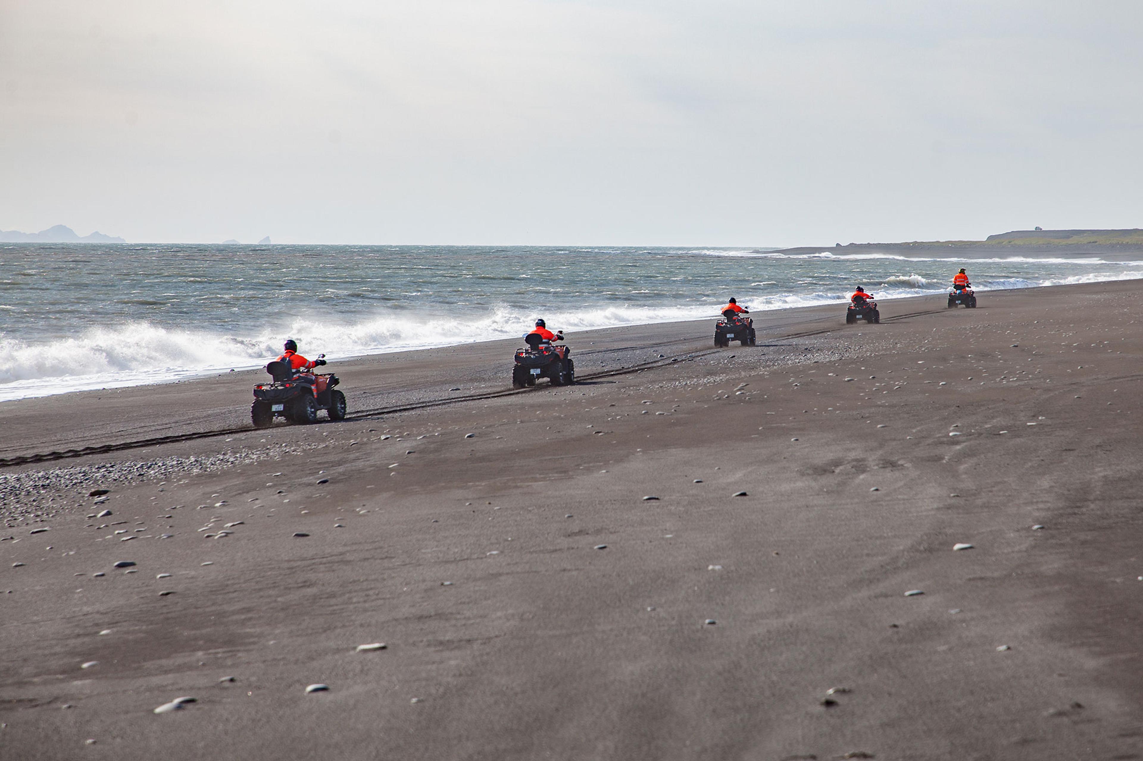 Riding on the black sand beach and the Atlantic ocean on ATV quad bikes