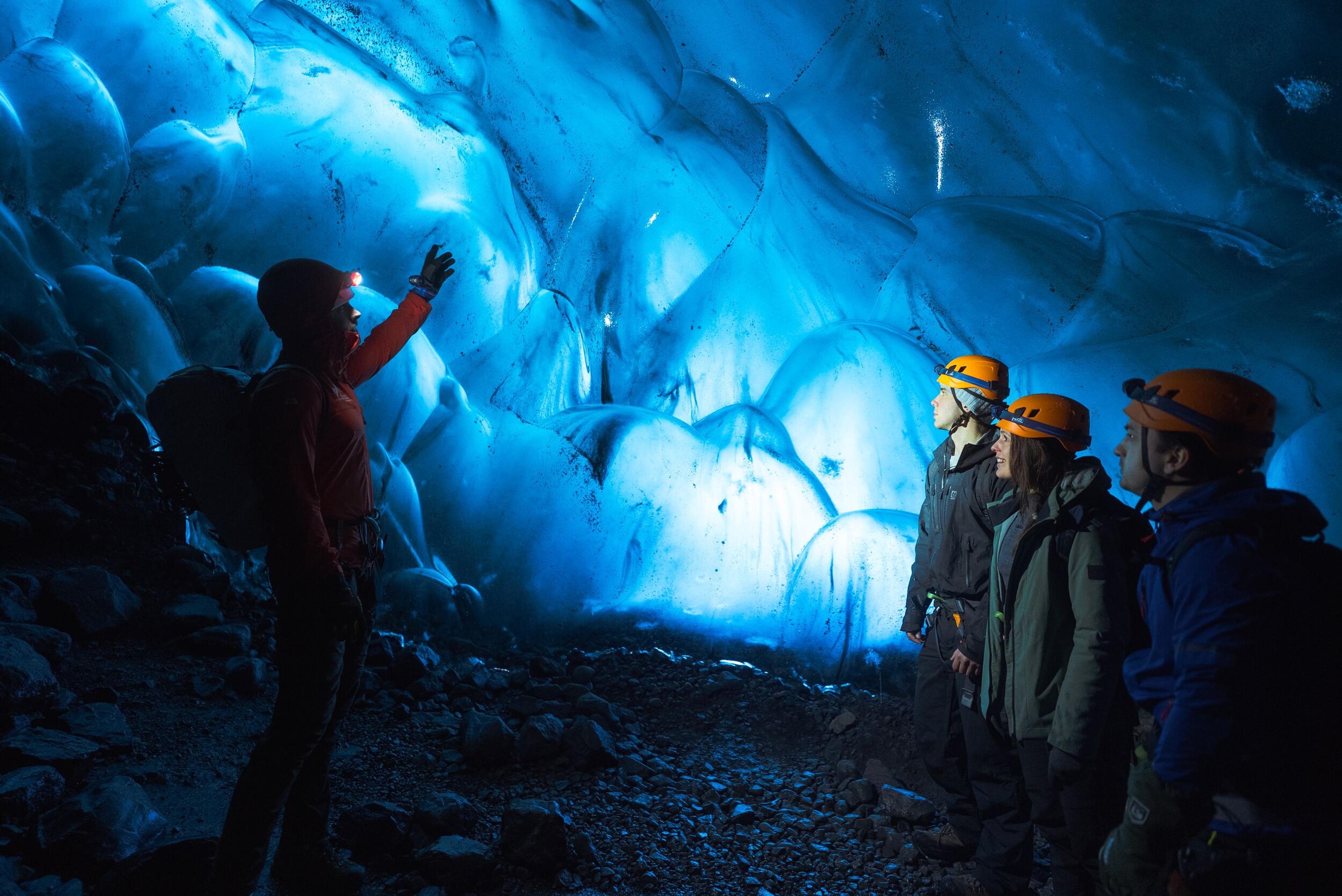 Icelandic Mountian Guide and people standing inside an ice cave at Vatnajökull in Iceland