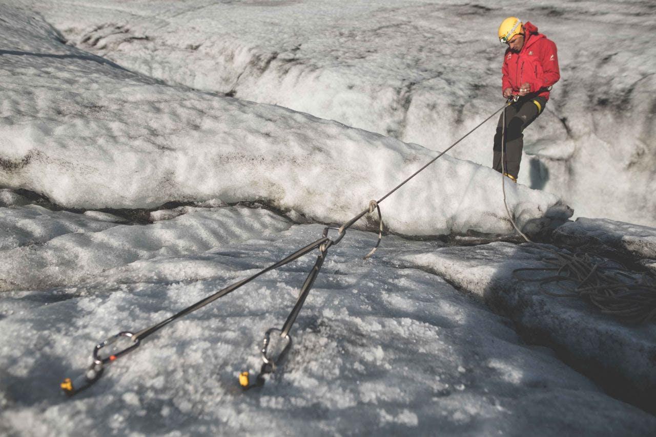 A man climbing ice wall in Iceland with Icelandic Mountain Guides