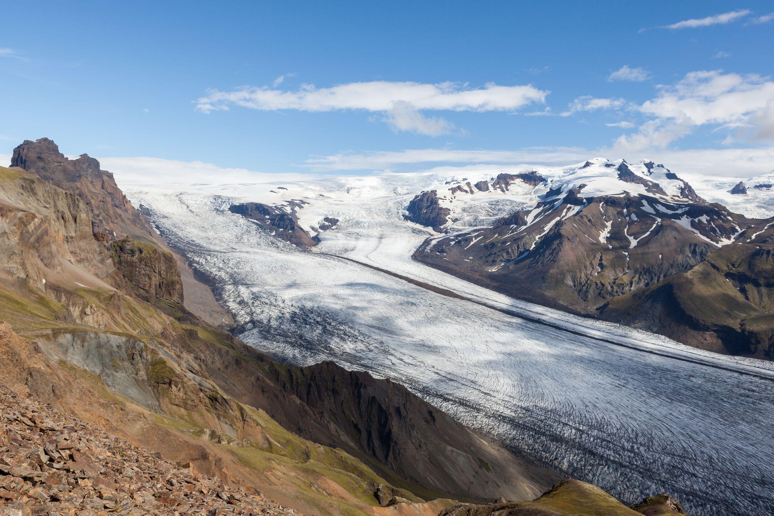View from Kristínartindar summit with sweeping glacier fields and rugged volcanic peaks in the distance.