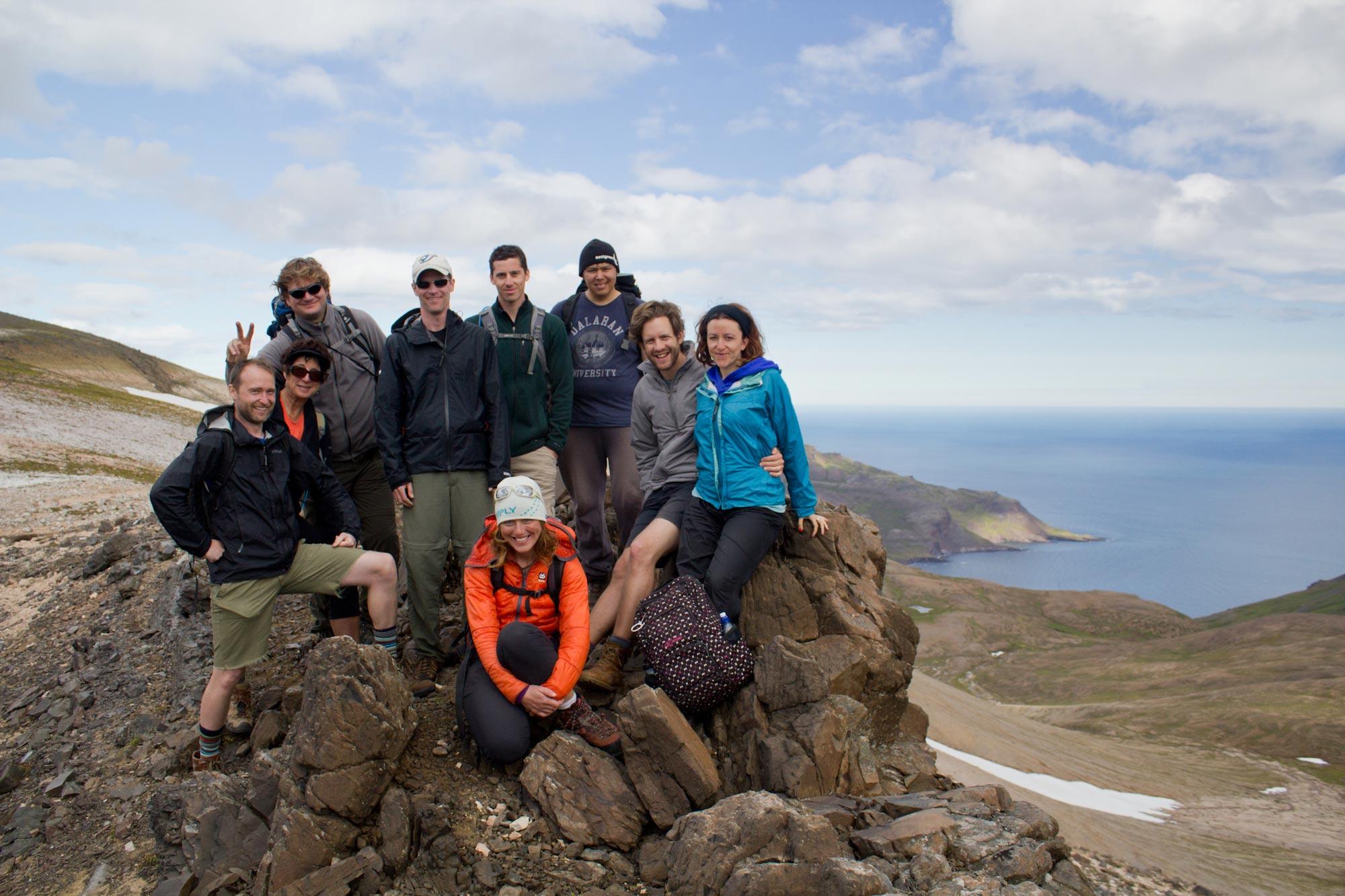 Hikers posing on rocks in the east fjords with the sea and blue sky in the background