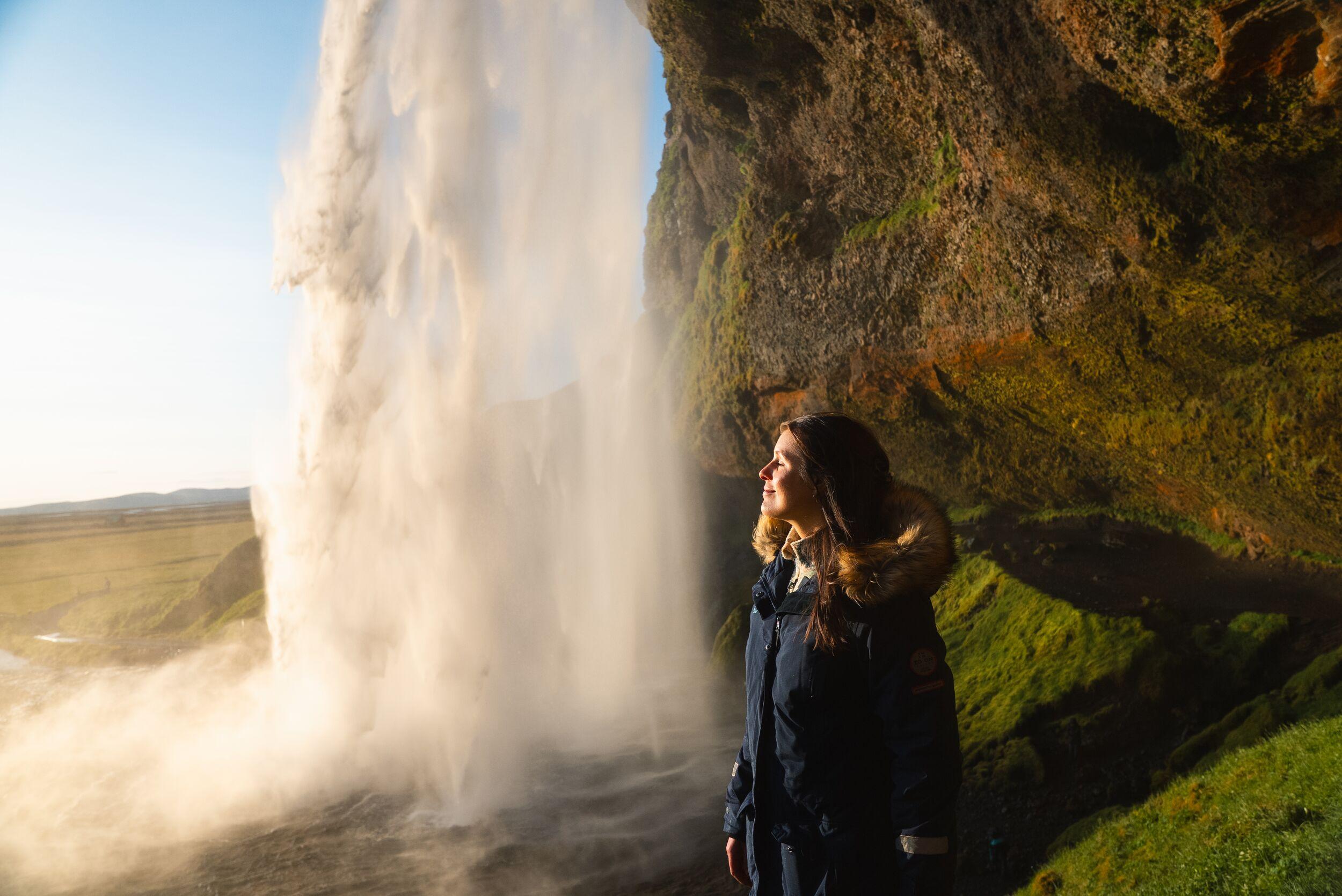 woman standing by a waterfall