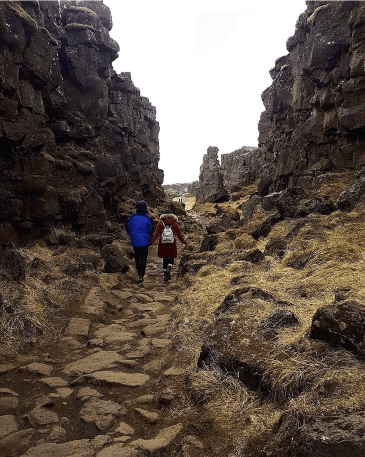 A couple walking through Þingvellir National Park