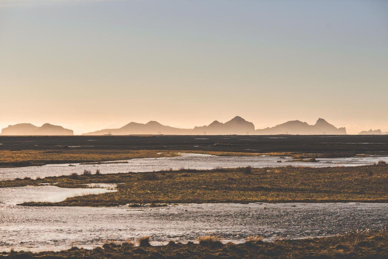 Calm river on a beautiful November day in Iceland, graceful mountains in the background