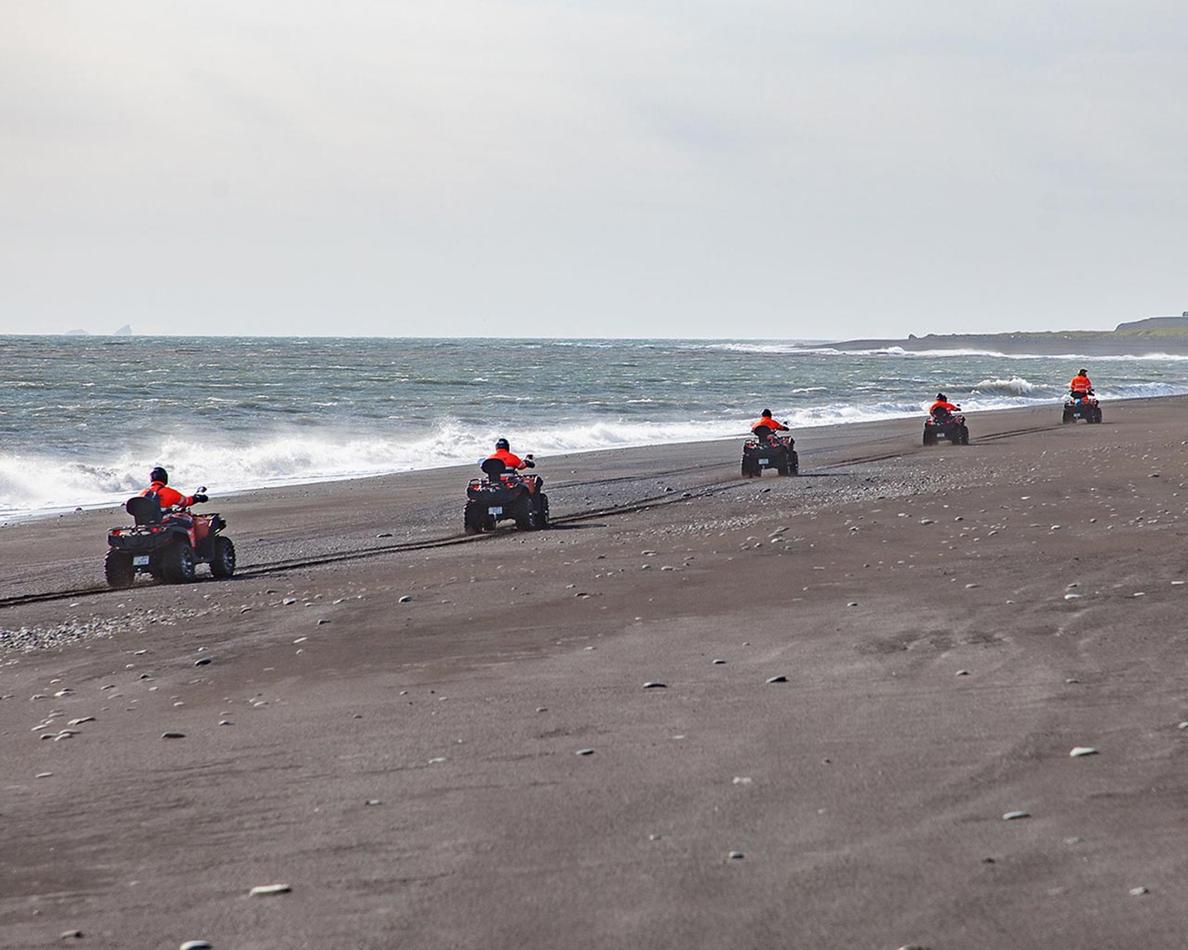 ATV quad bikes driving on the black sand beach