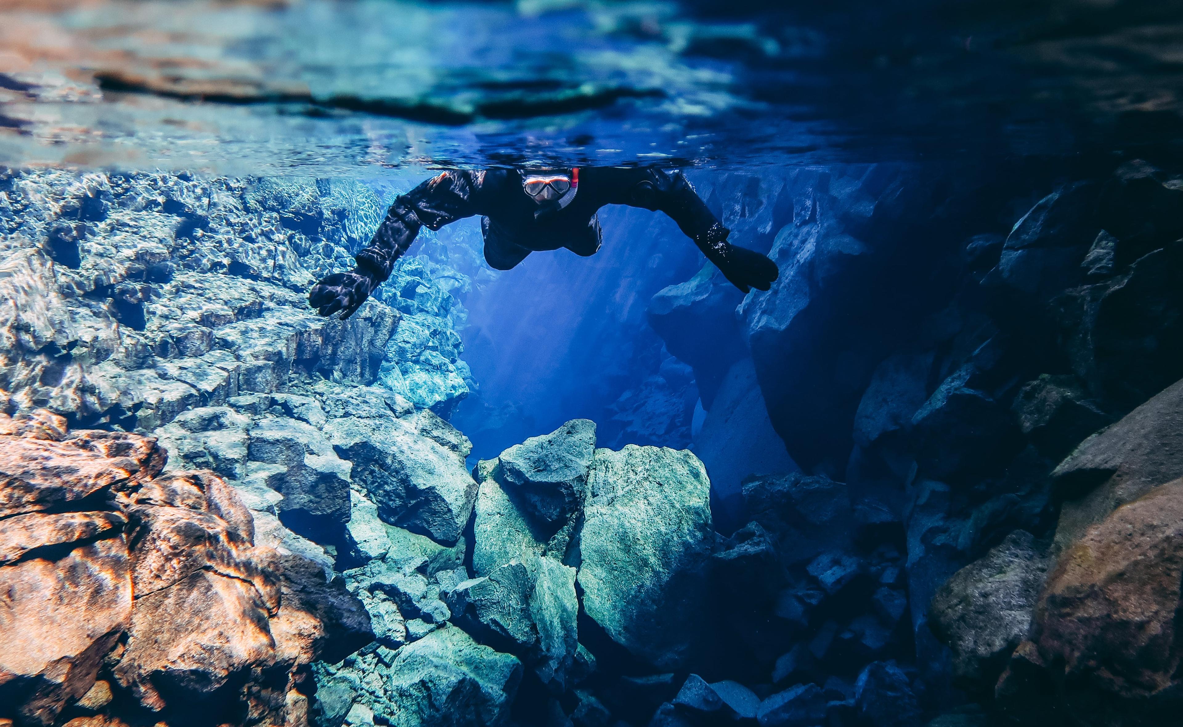 A person swimming towards the camera in Silfra fissure