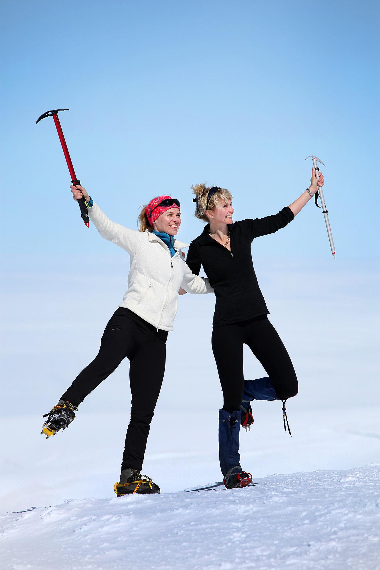 Two hikers posing with ice axes on Hvannadalshnúkur mountain.