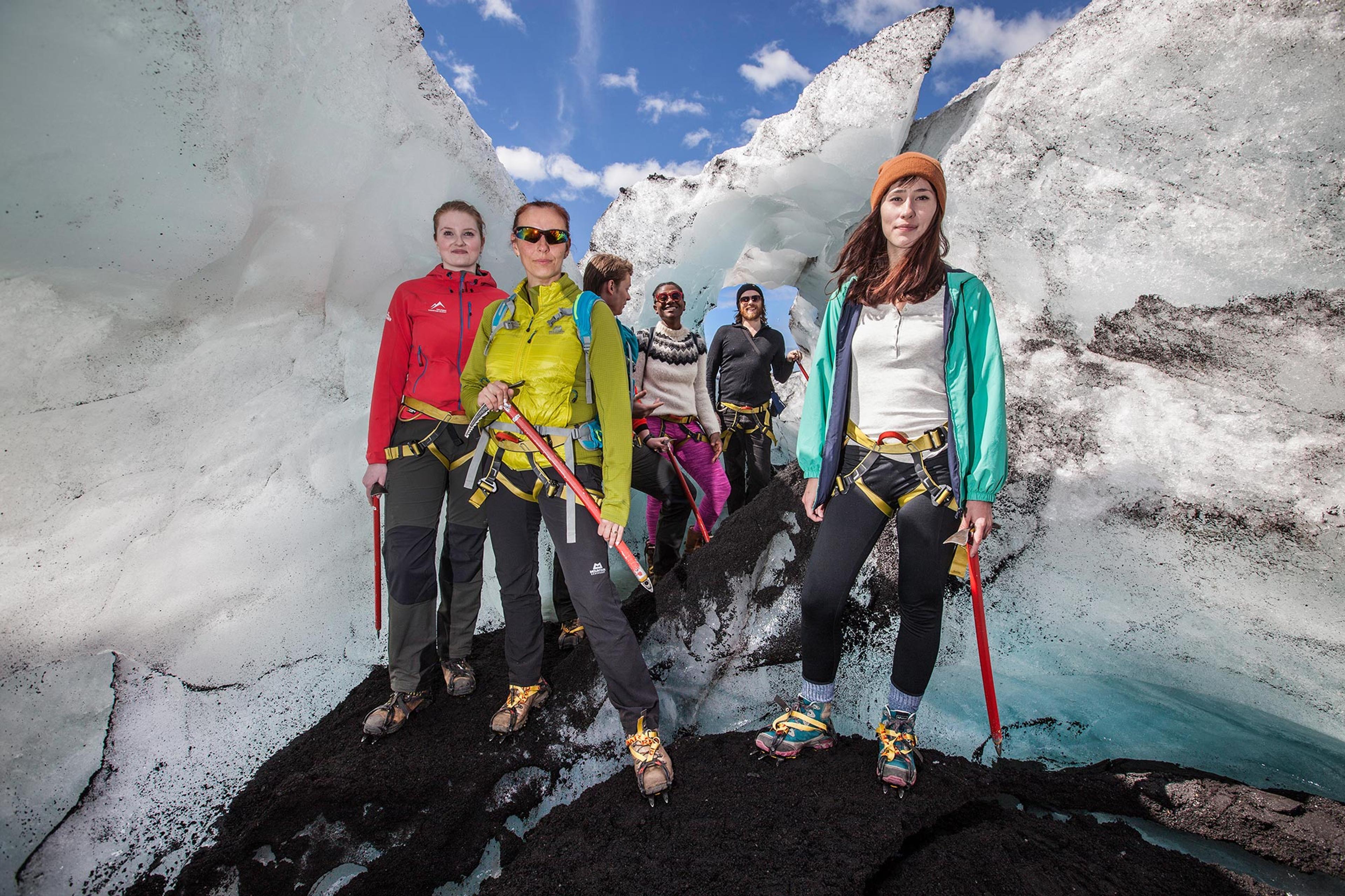 People posing for picture on glacier walk on Sólheimajökull on sunny day