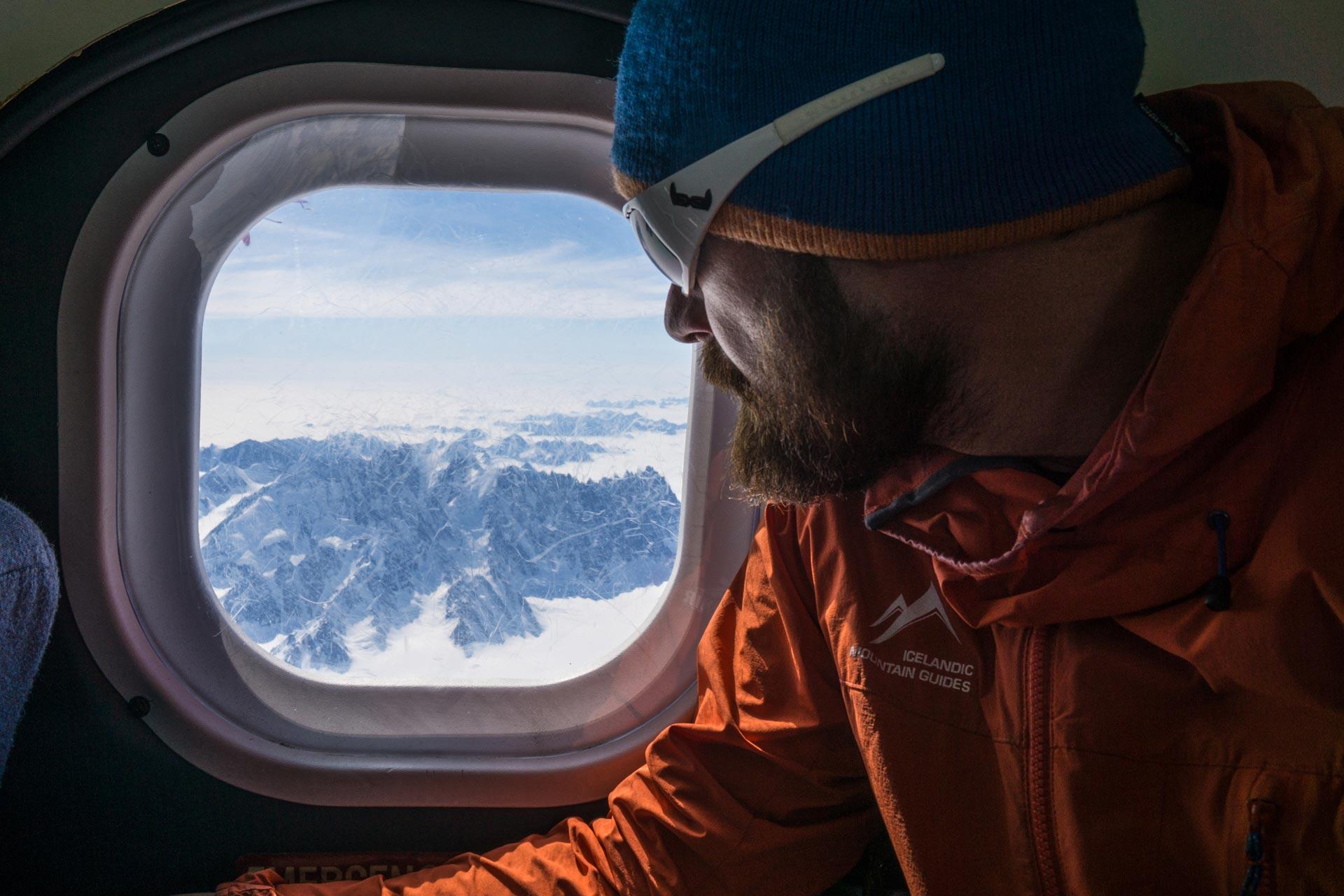 a man looking out of the window of the ski plane