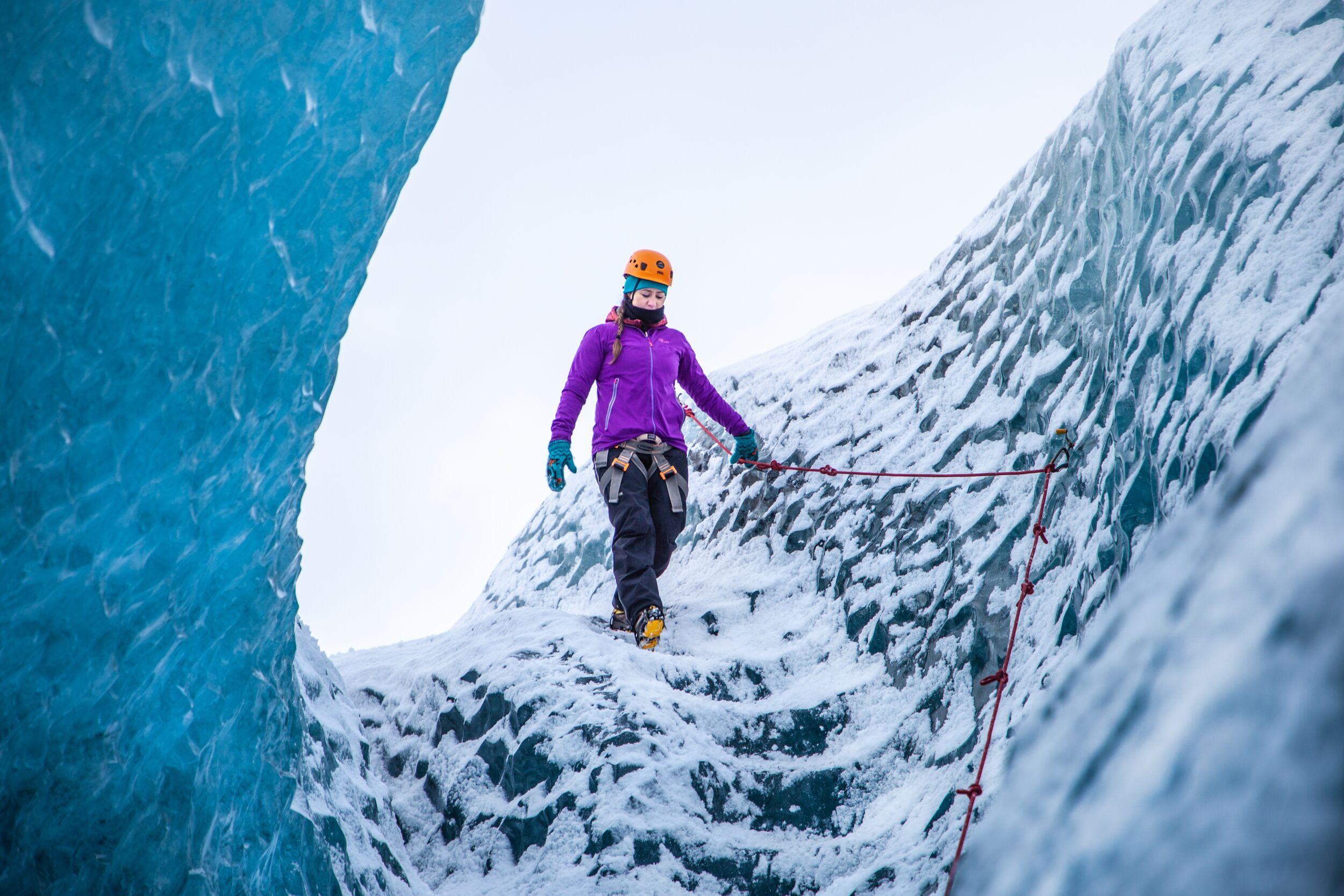 person walking on a blue glacier