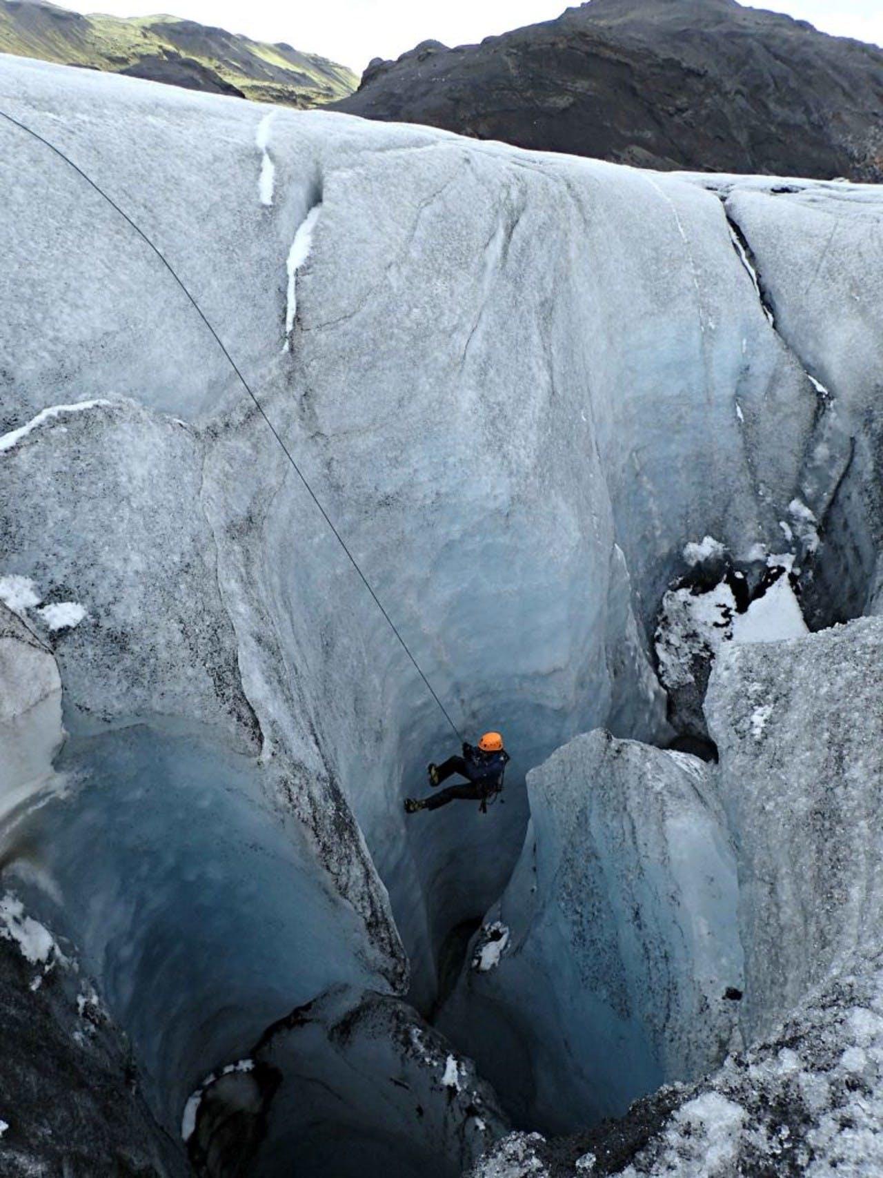 man climbing up a glacier