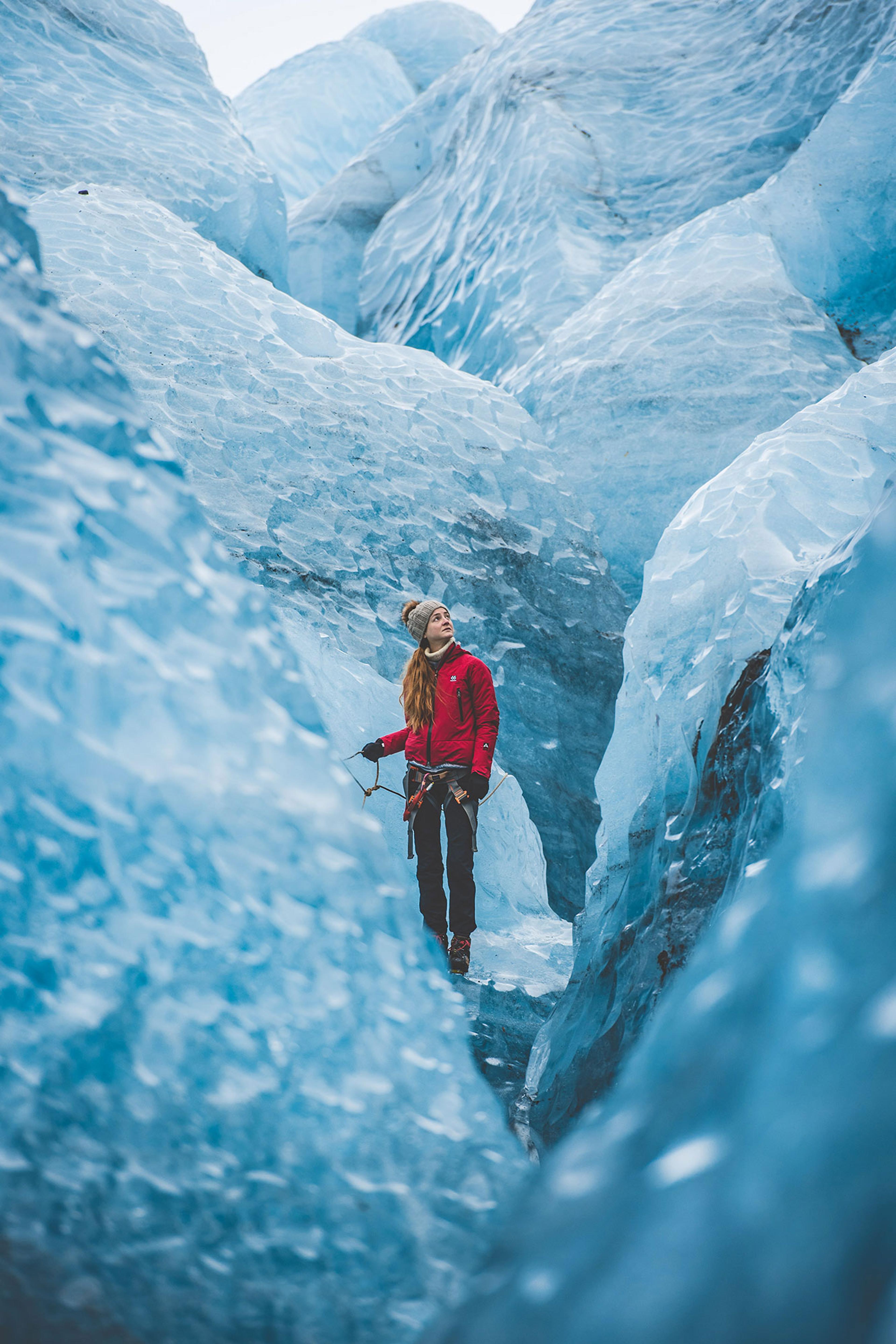 A girl inside a very blue crevasse