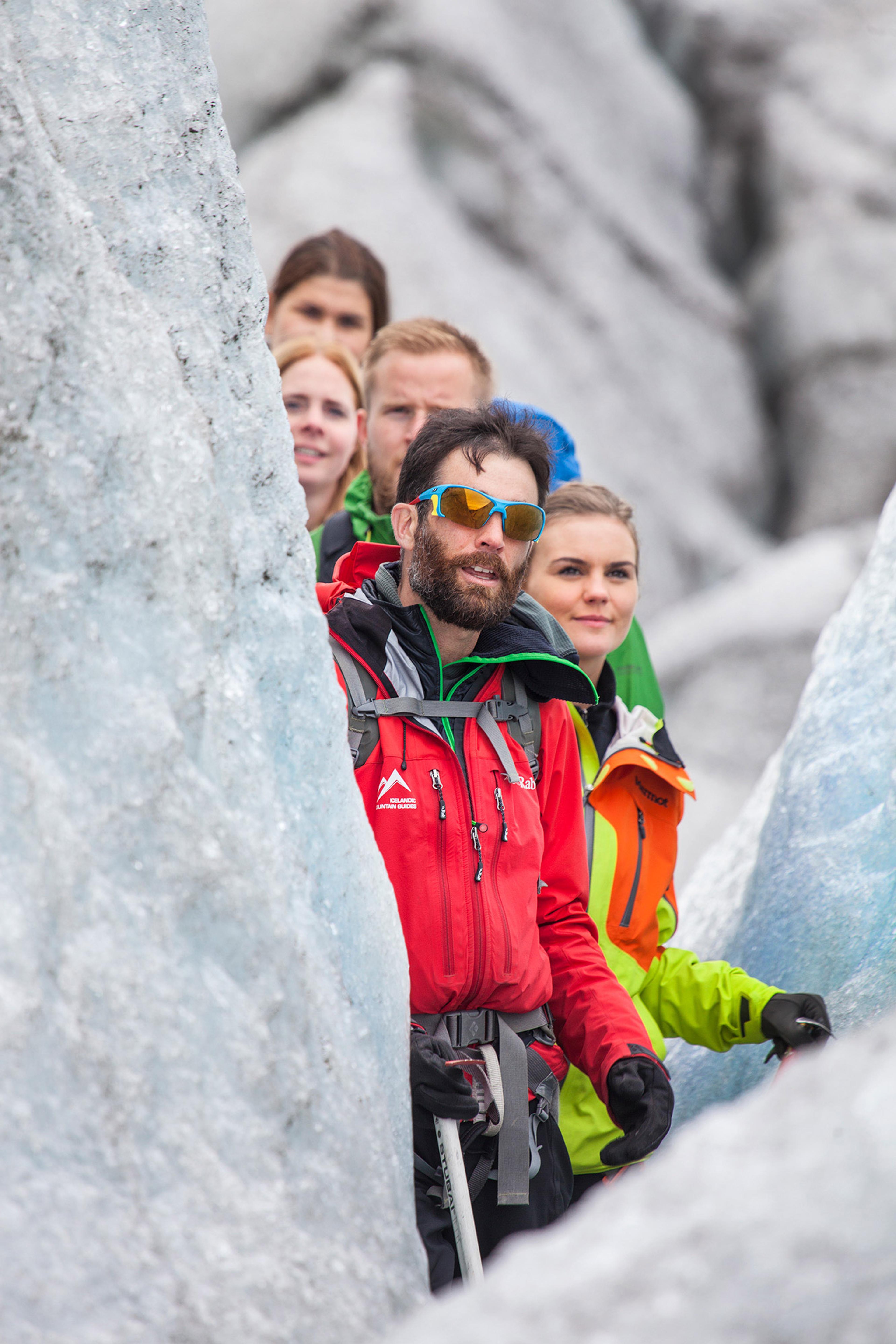 Guide from Icelandic Mountain Guides leading a group in a crevasse on a glacier.
