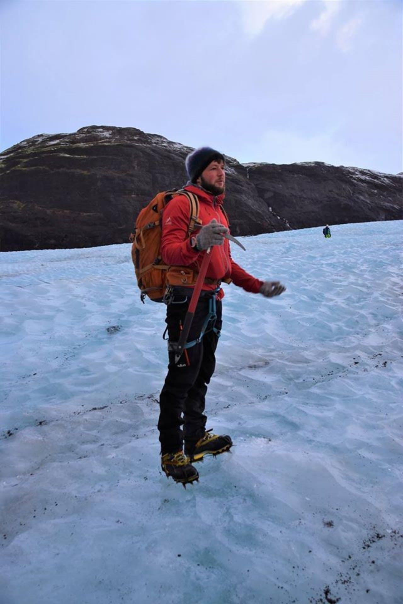 Man in red standing on a glacier