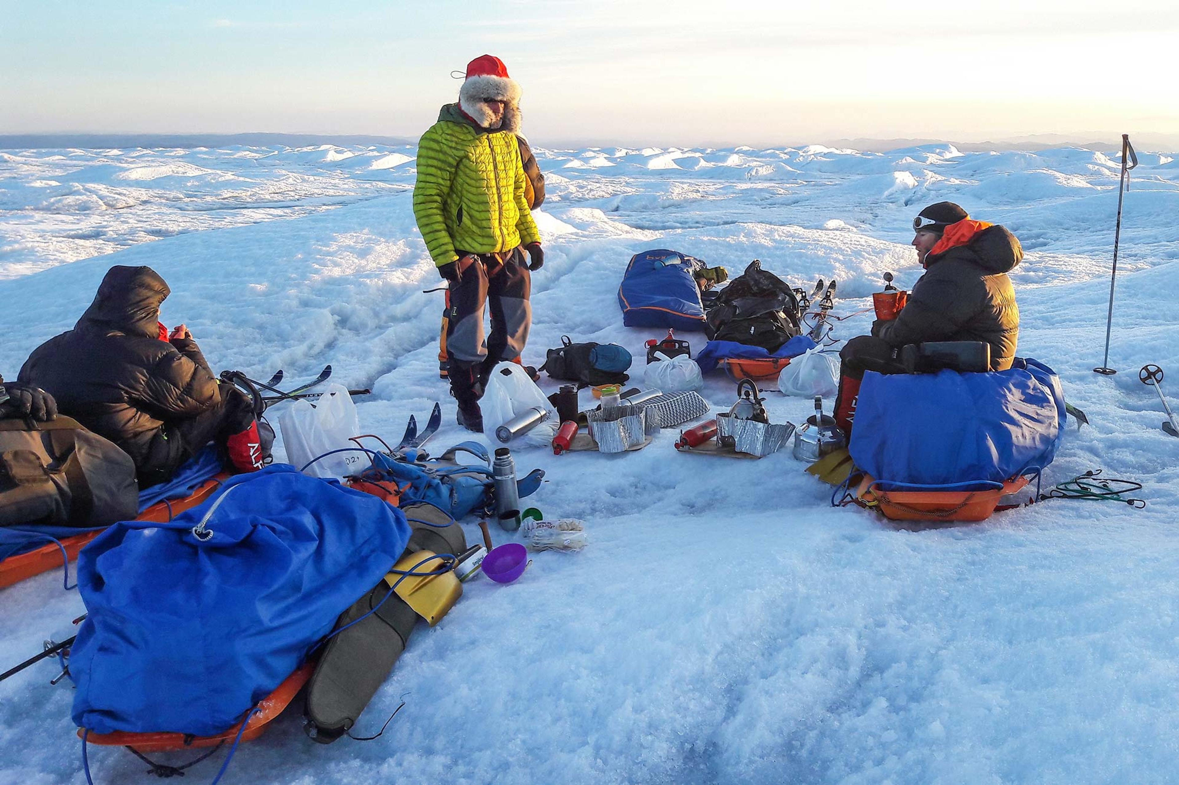 Four men taking a little break from skiing on the glacier having some lunch
