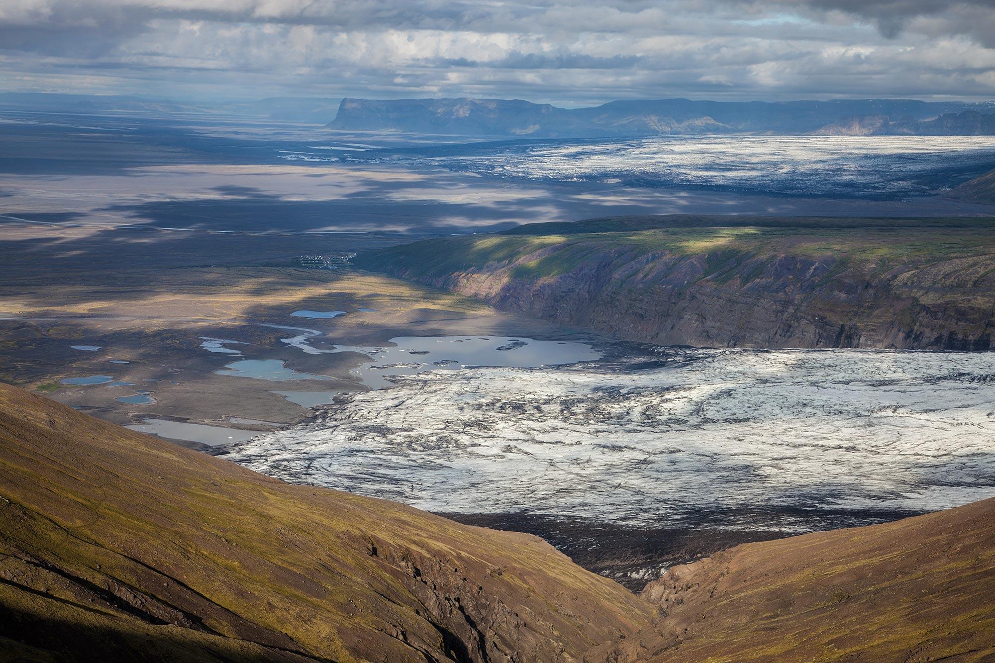 Looking down at a glacier from a height on a cloudy day.