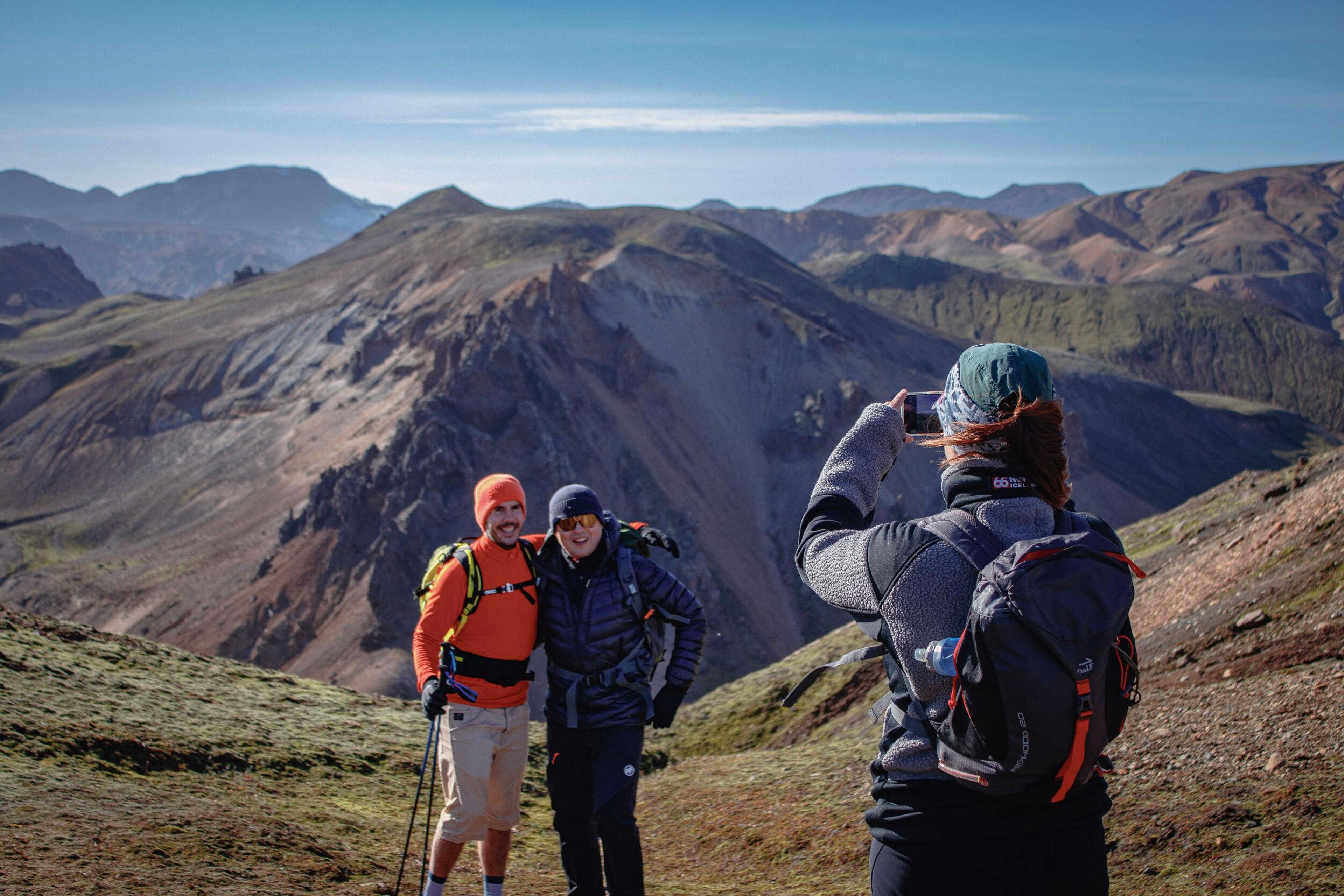 person taking a picture of two people in a landskape