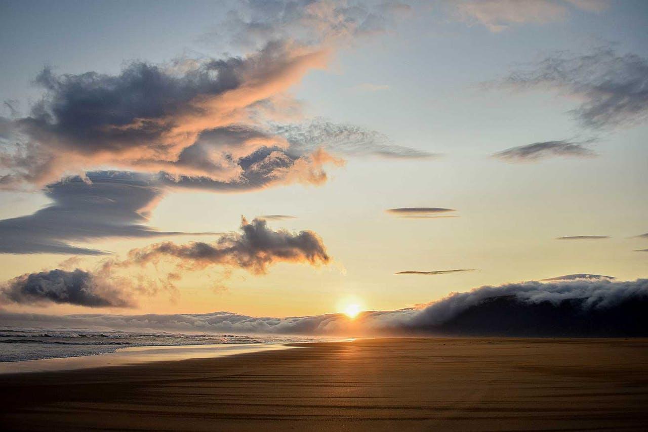 Orange sunset on a beach with a semi cloudy sky in Iceland in July