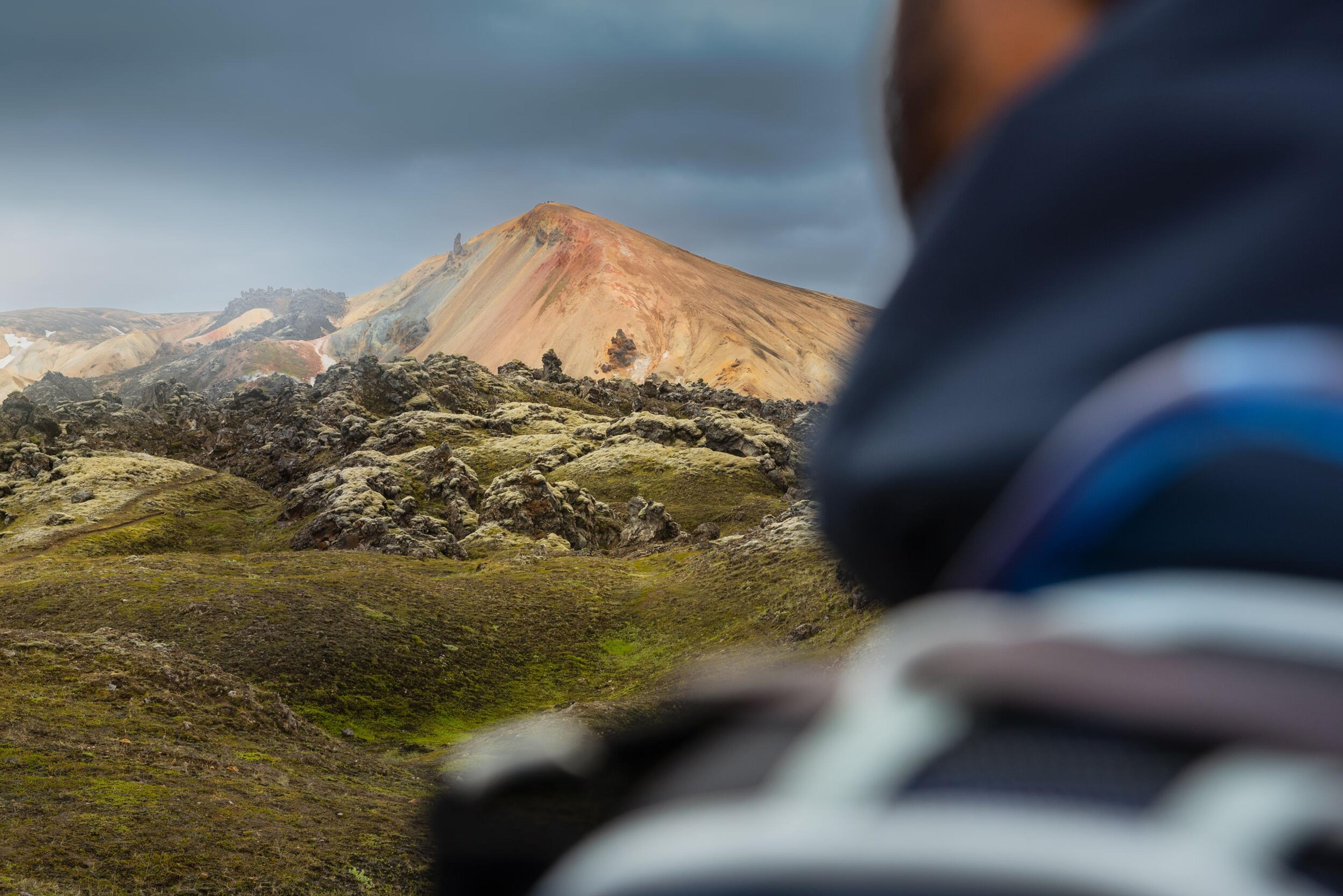 hiker looking at mountains and lava field in Landmannalaugar in Iceland