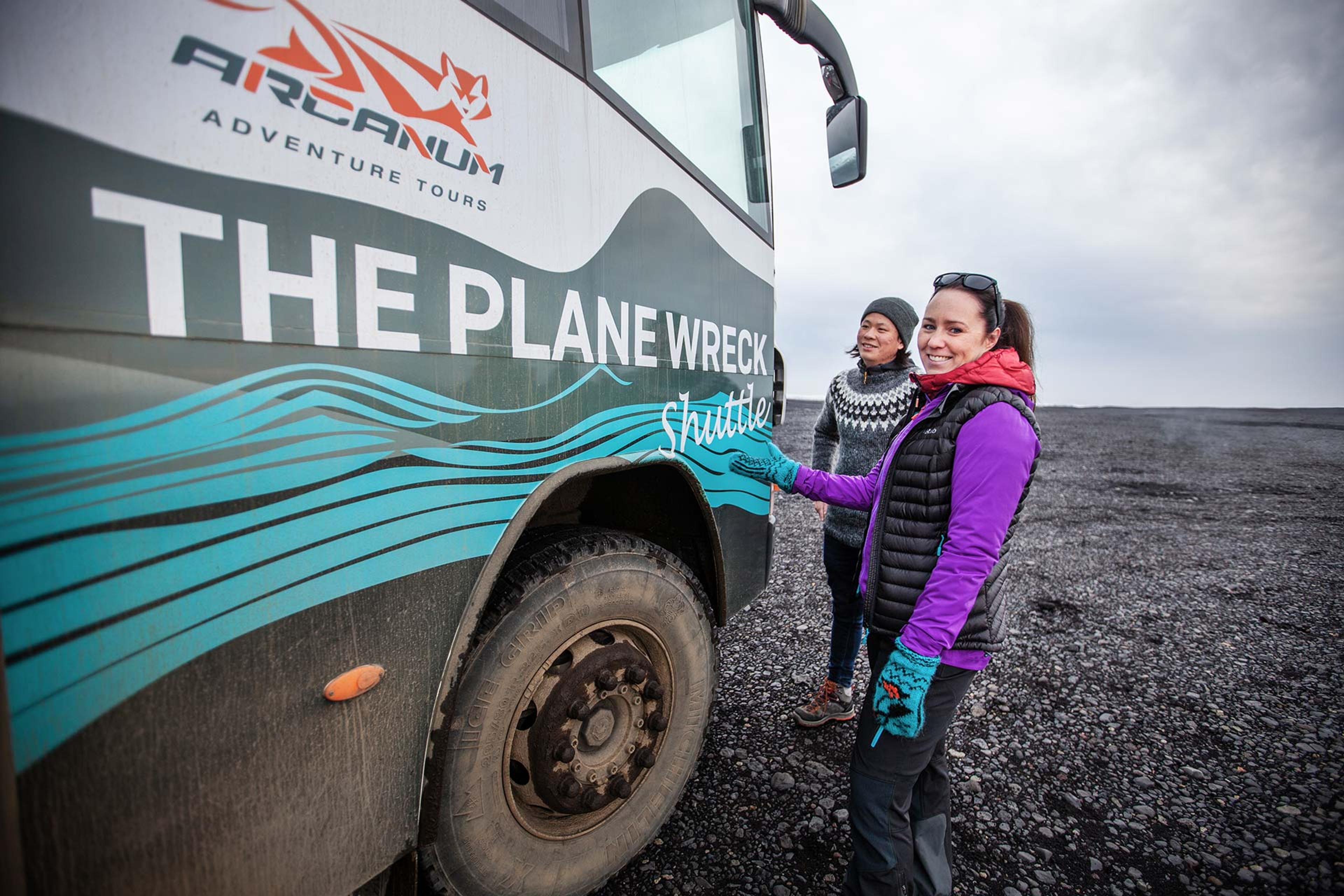 A couple standing by the plane wreck shuttle