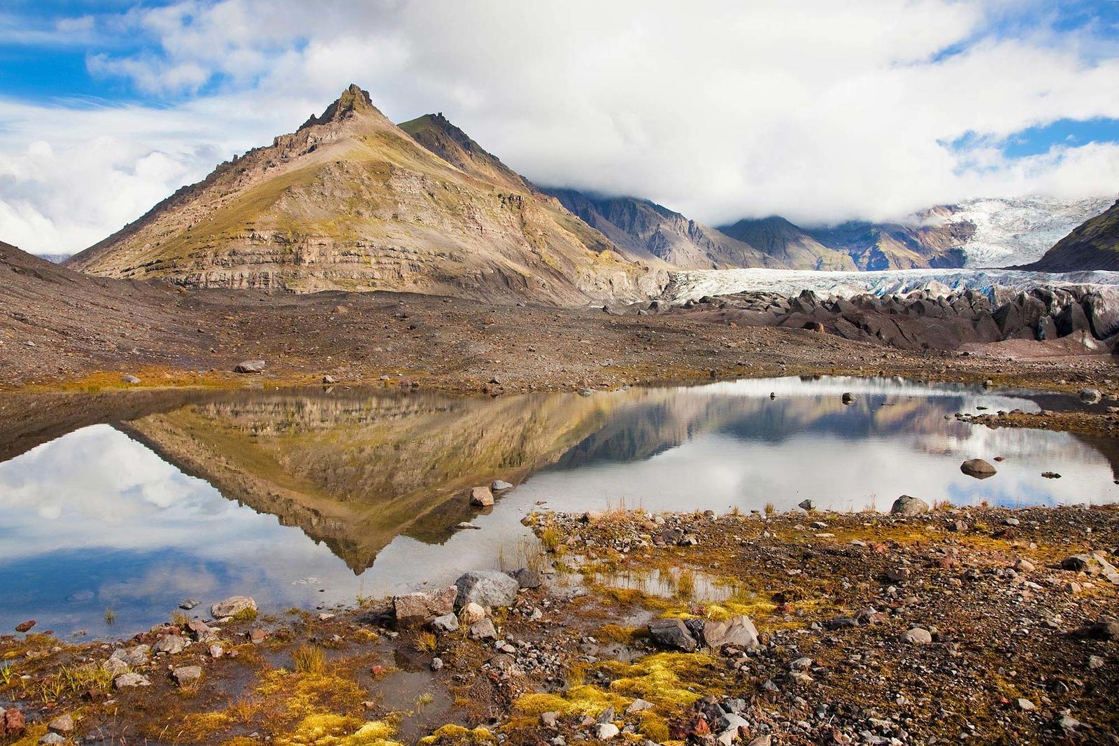 A warm coloured mountain reflecting in the water.
