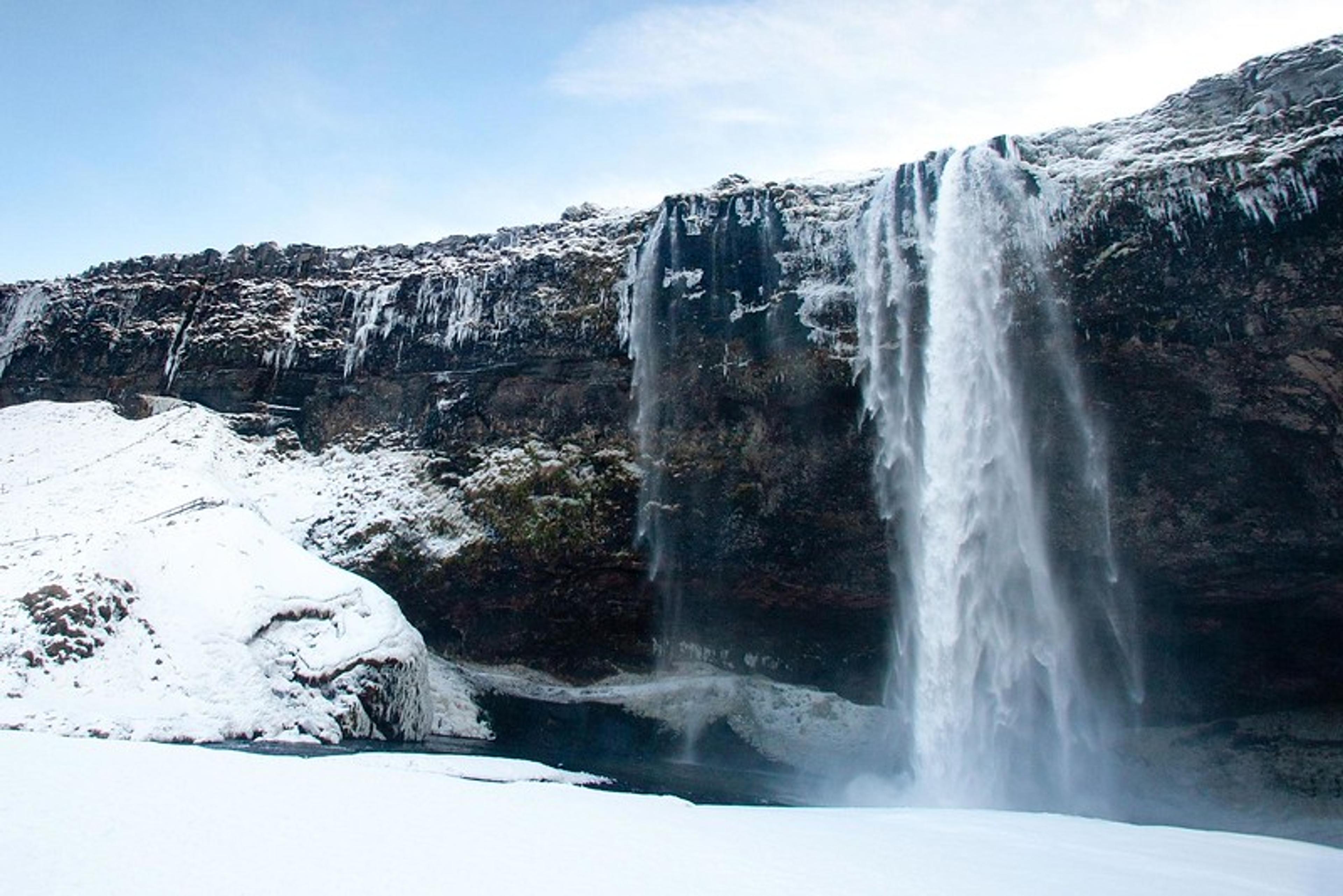 Seljalandsfoss waterfall in wintertime with snow all around