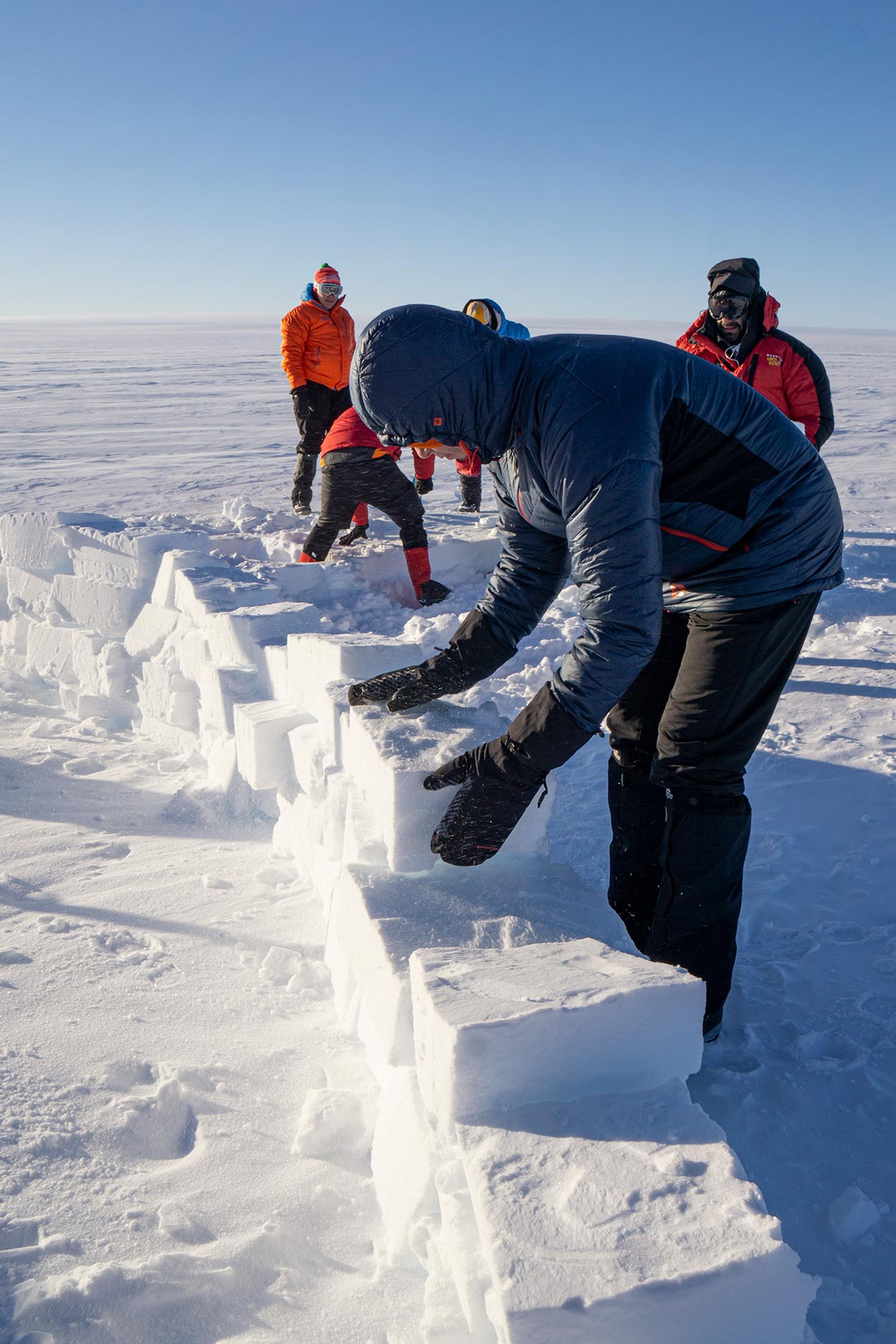 People building a snow wall to protect the tents from high winds