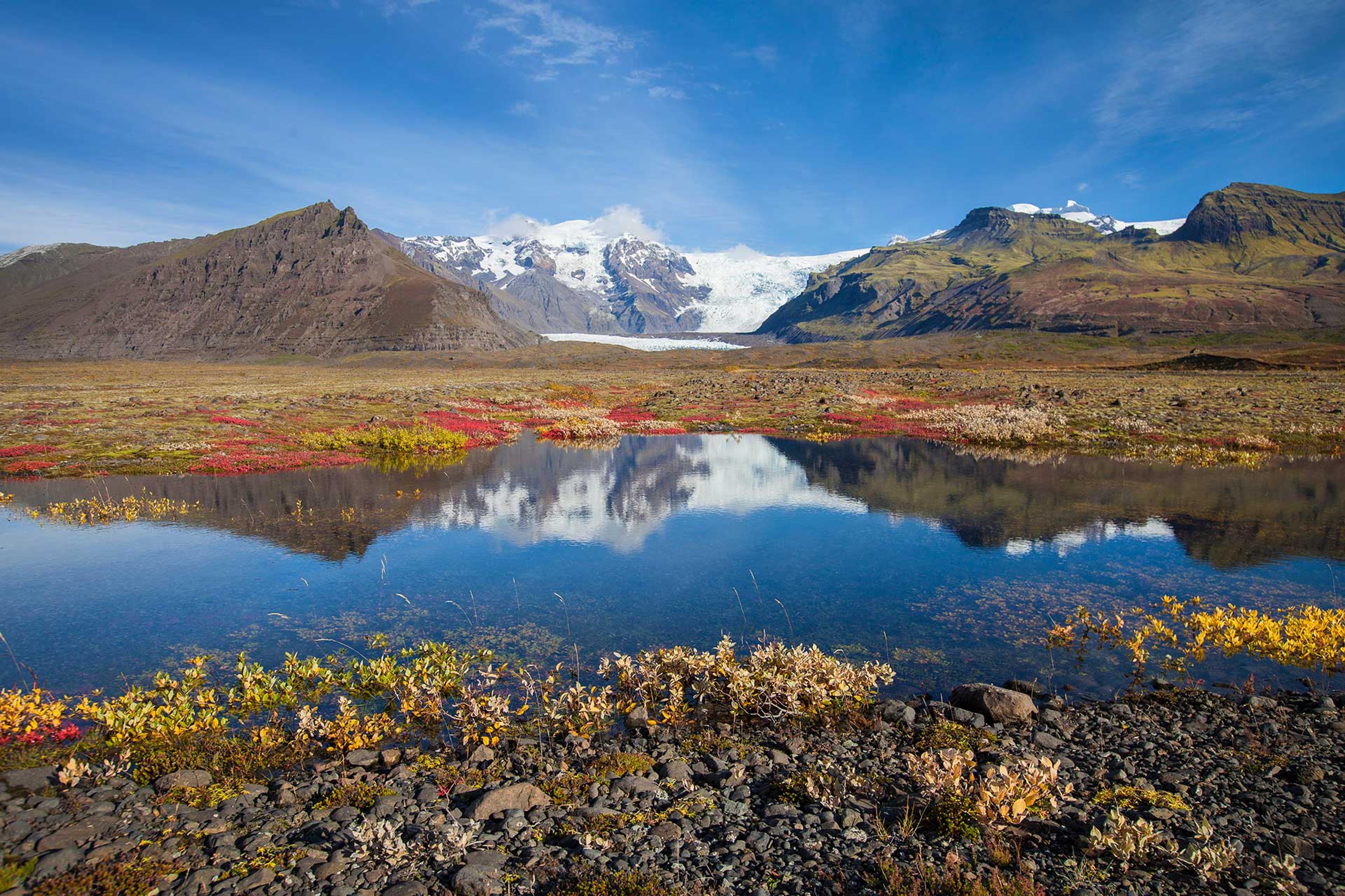 Hrútsfjallstindar peks in the background and a beautiful pond in the foreground with a reflection.