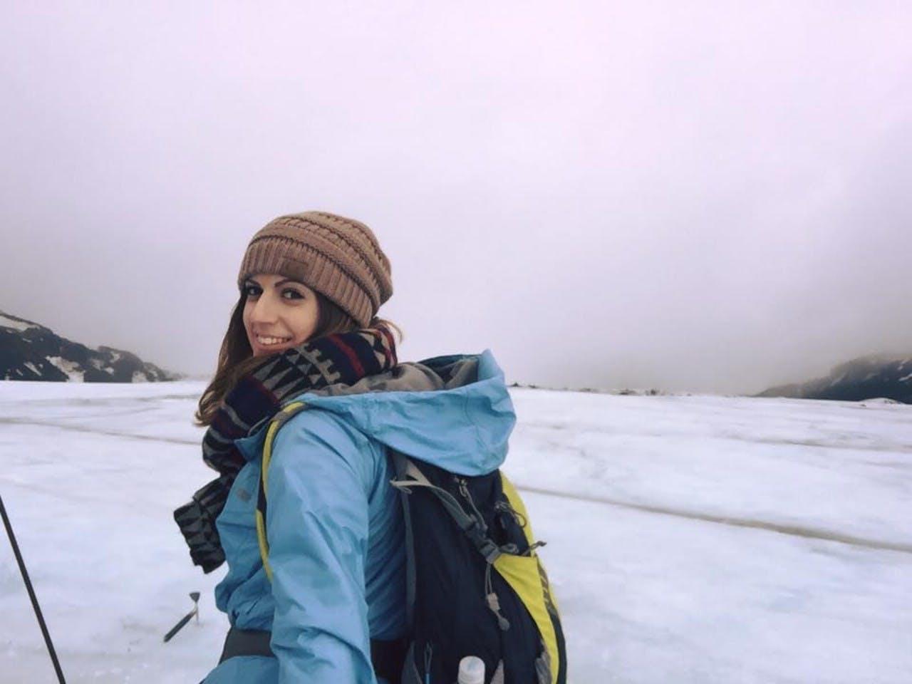 a woman smiling in the Icelandic nature under a purple sky