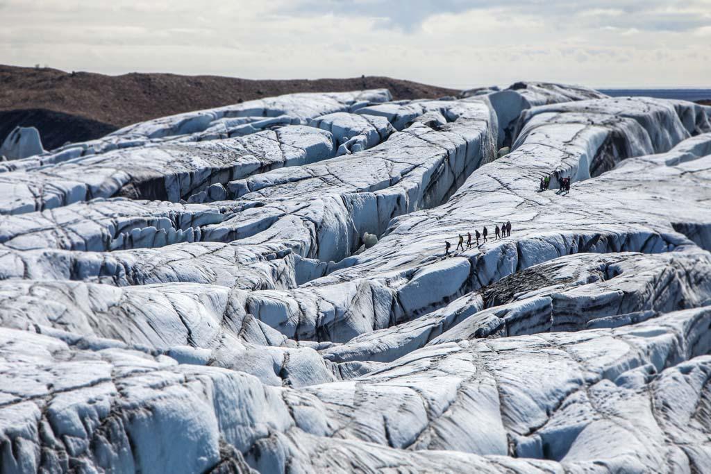 Hikers crossing a rugged glacier in sunny weather