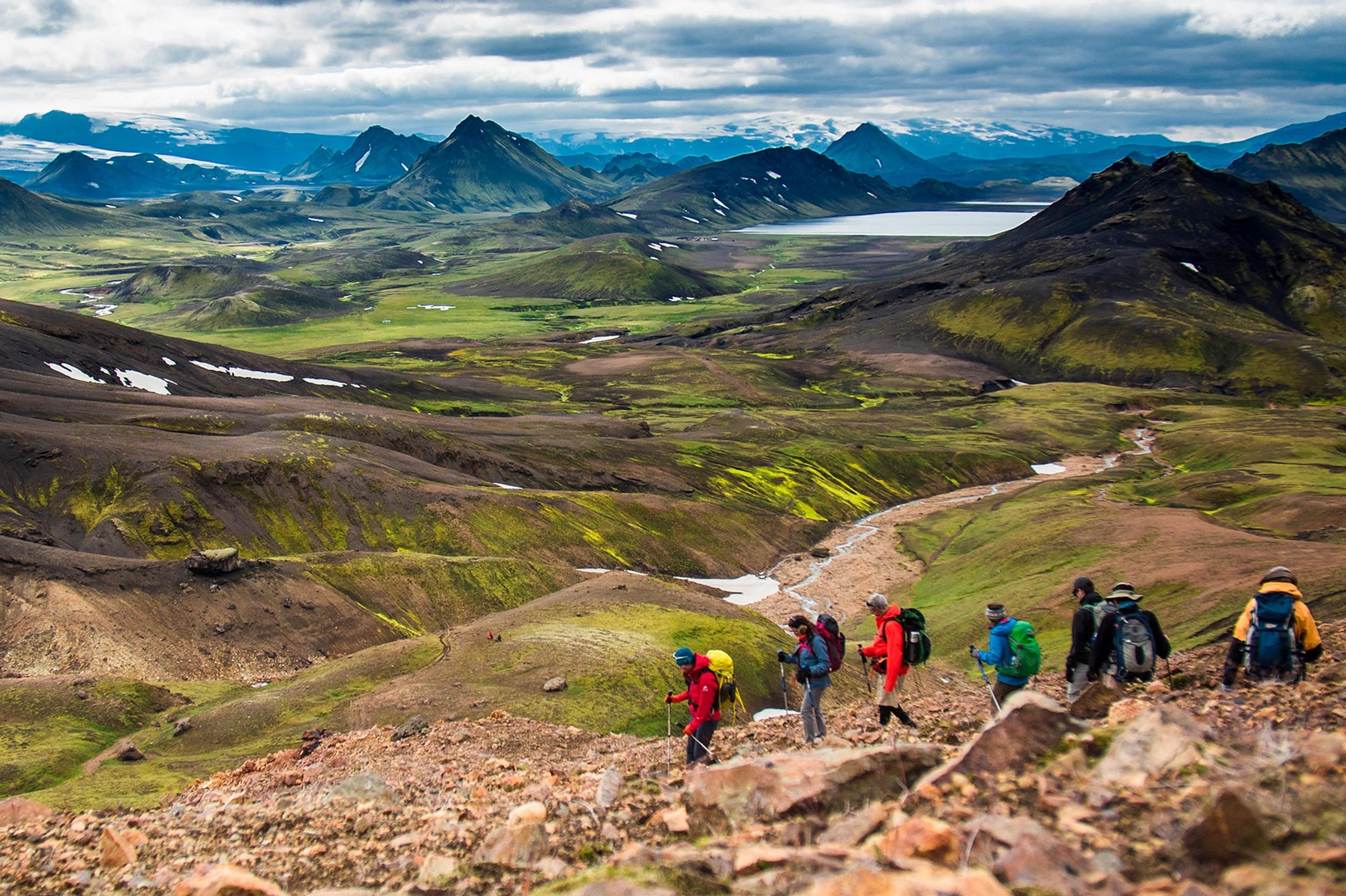 People walking the Laugavegur trail in Icelandic nature with blue and green mountains before them