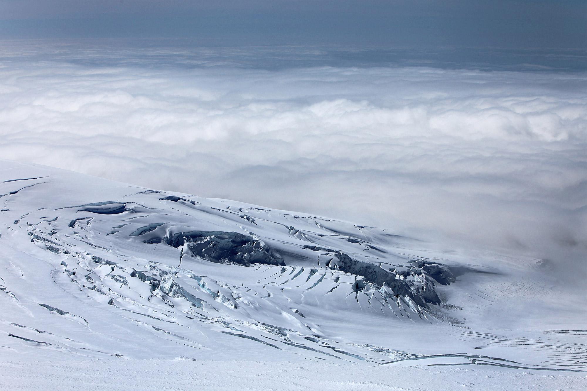 A blush white cloudy sky over the icy Hvannadalshnúkur mountain in Iceland.