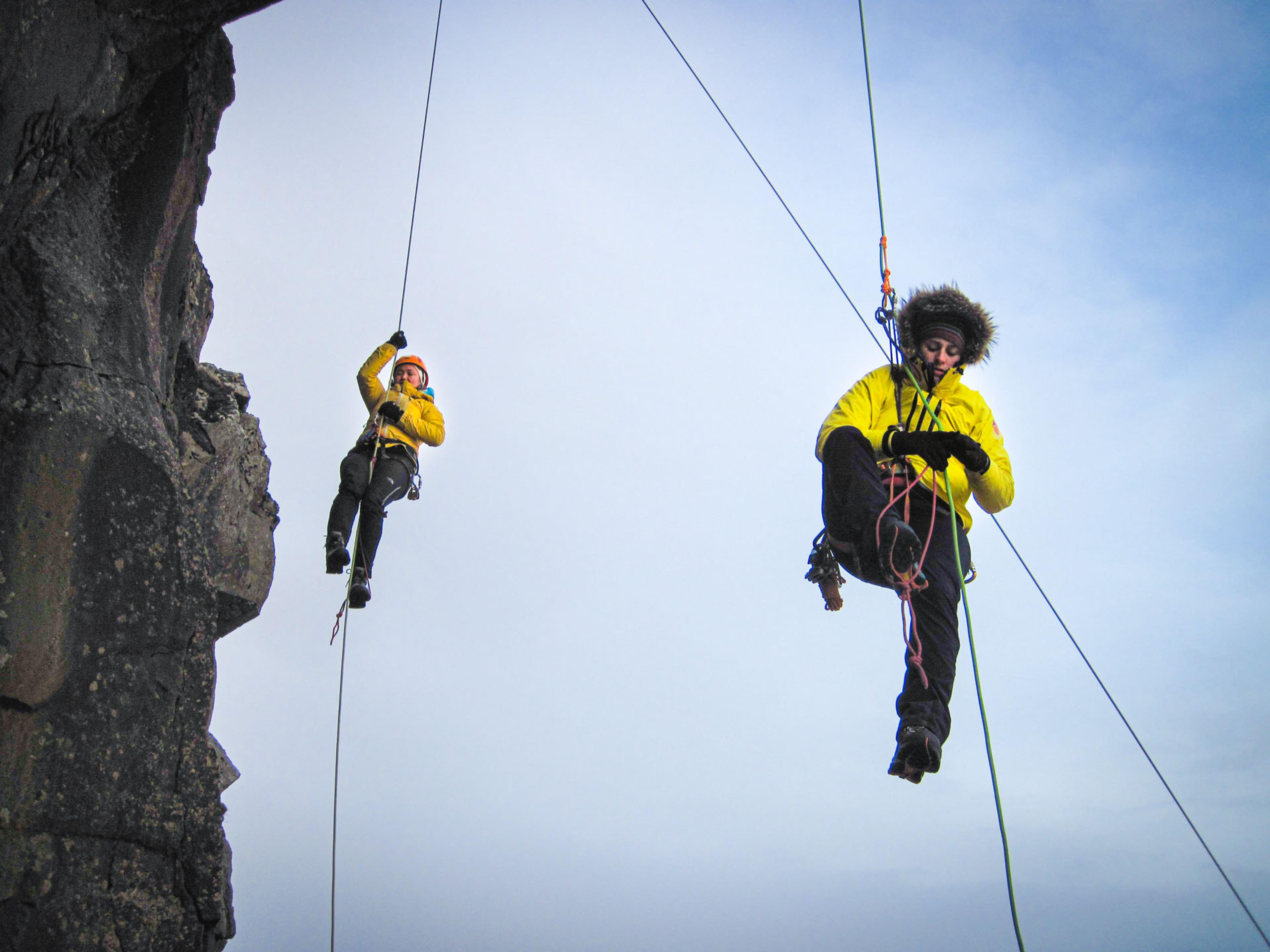 people mountain climbing in ropes 