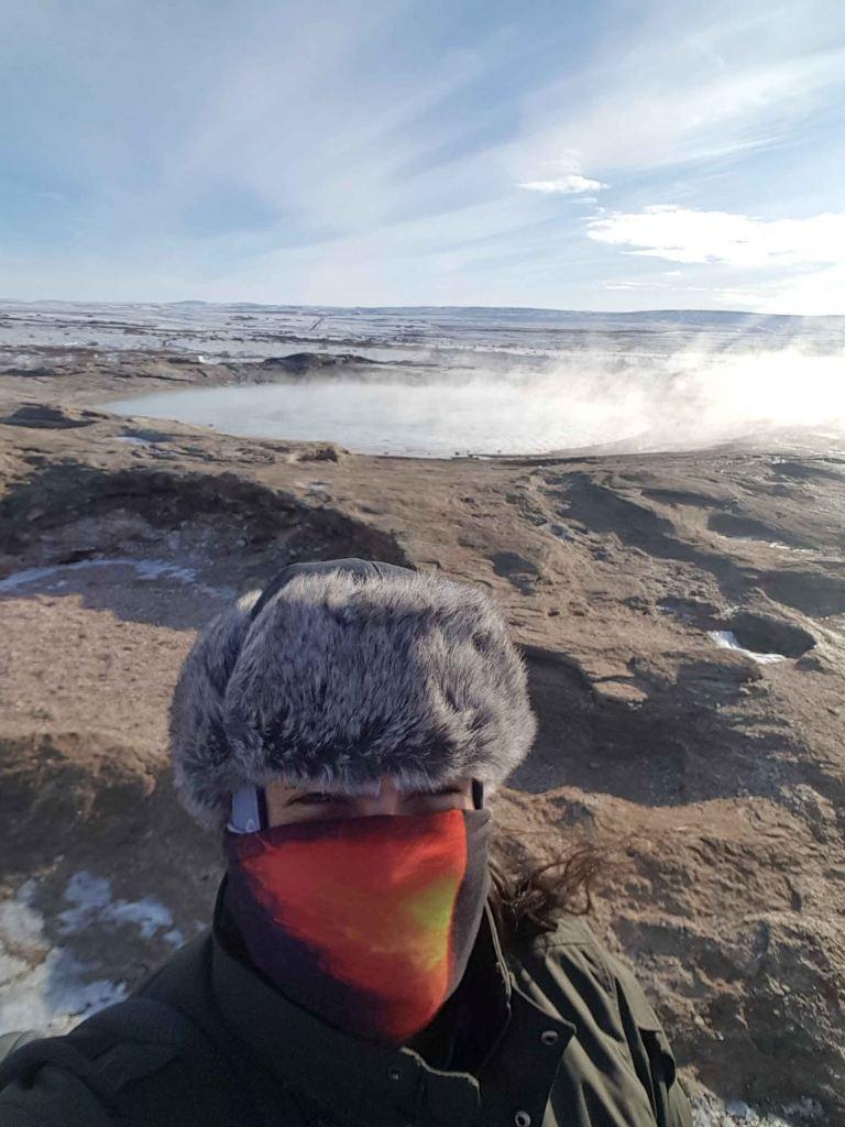 A selfie of a man in the sun with Geyser in the background