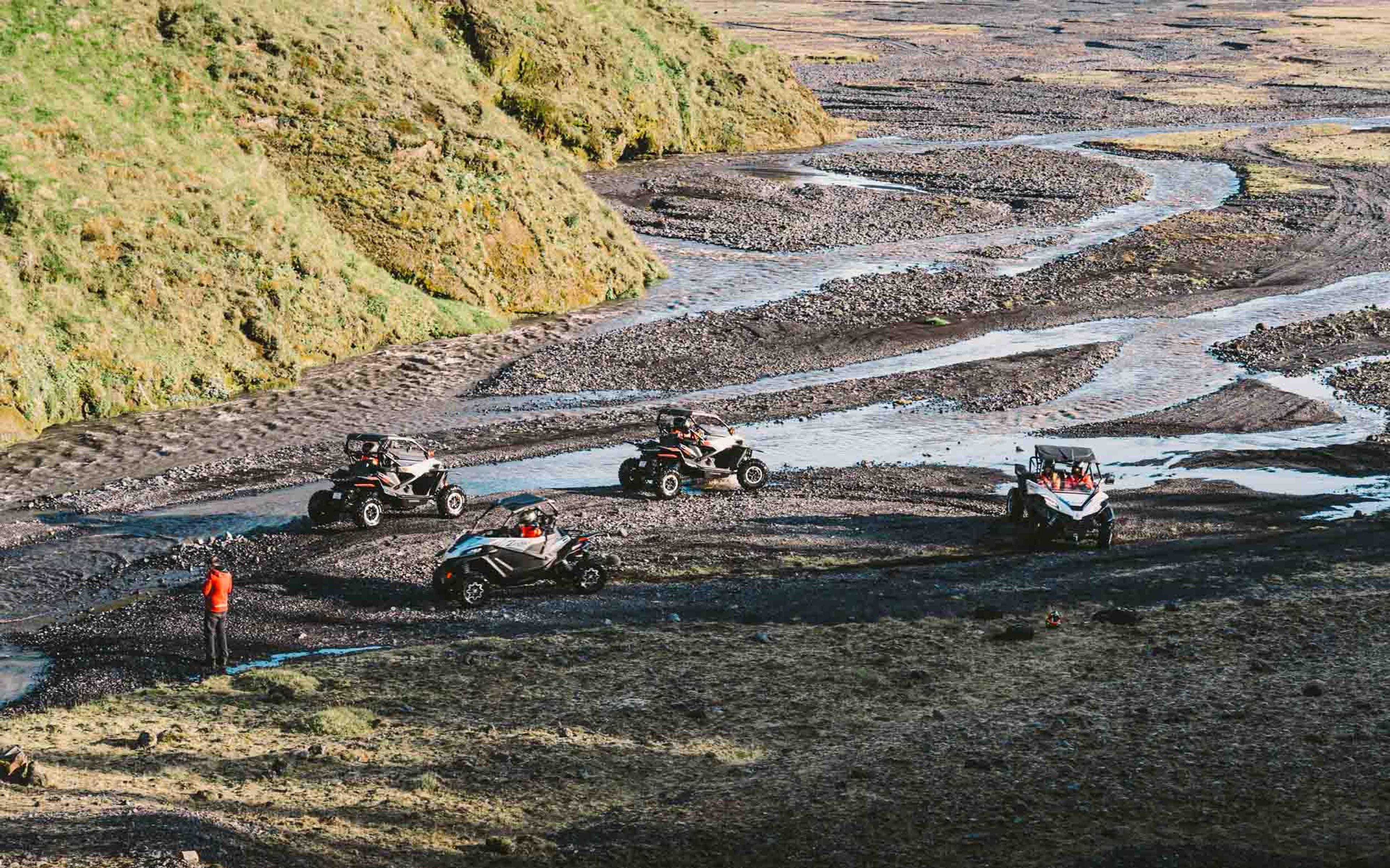 A group of buggies driving on a river bed in Iceland