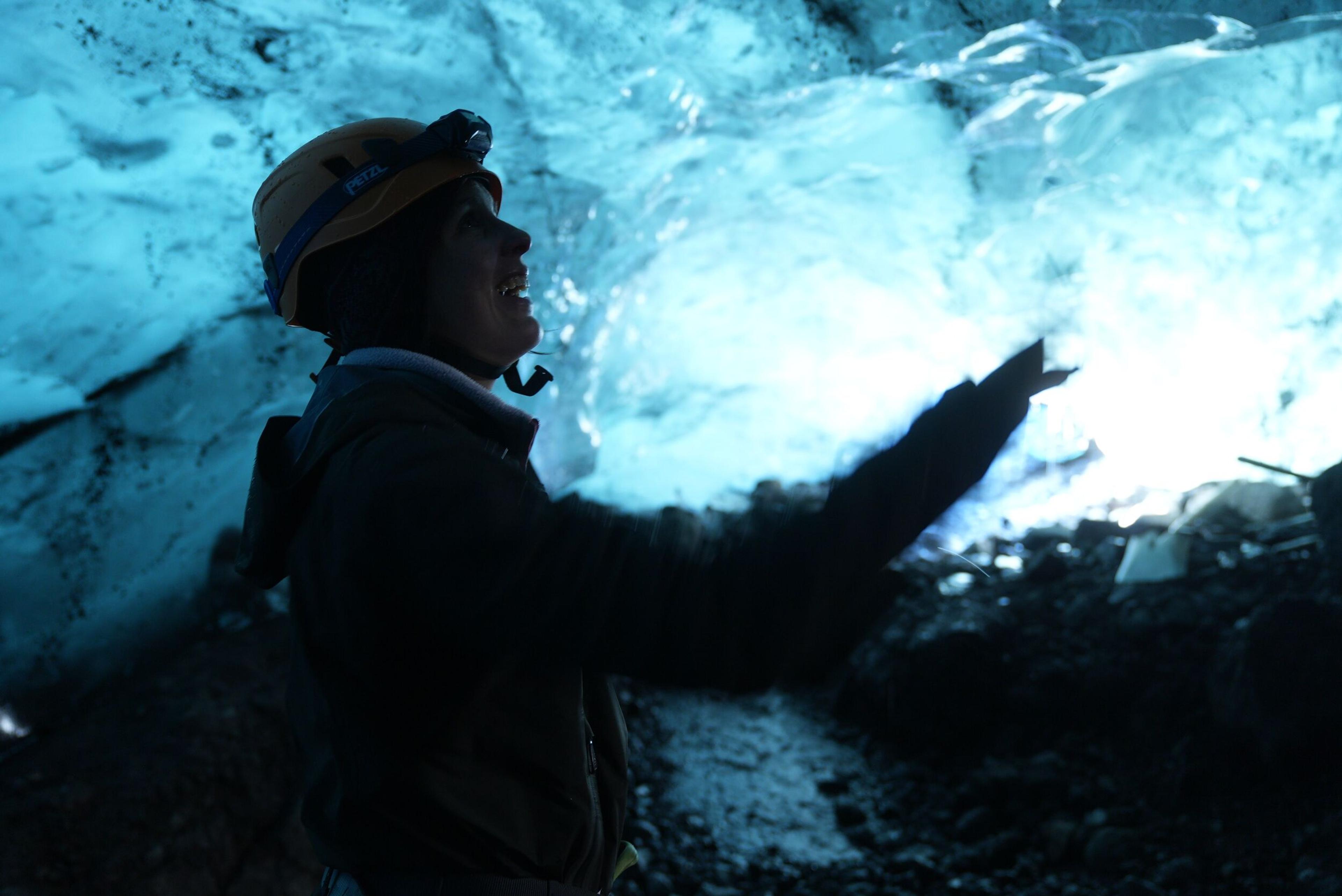 A person enjoying the blue ice inside an ice cave in Iceland